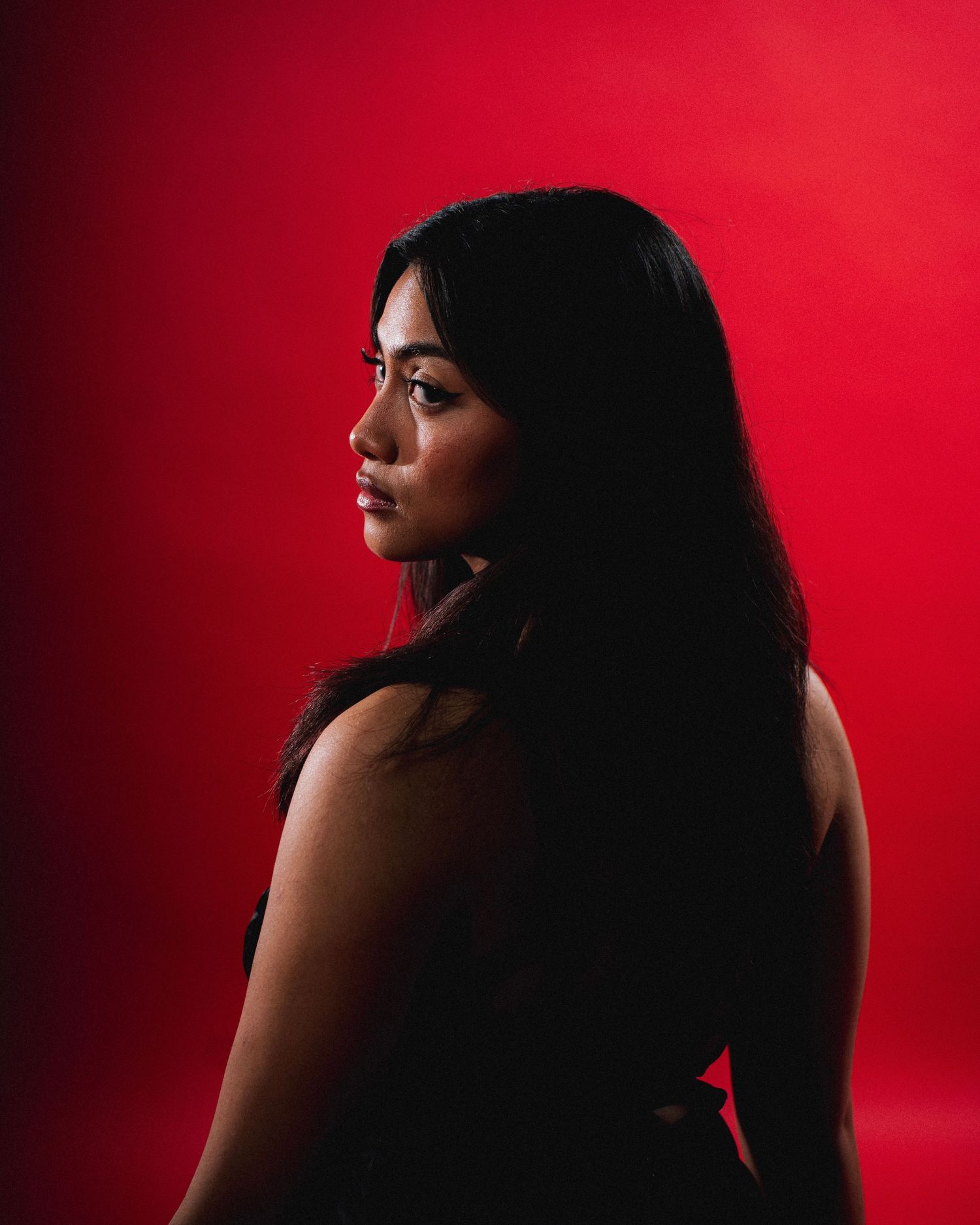 A dramatic silhouette portrait series against a vibrant red background showing different angles and shadows.