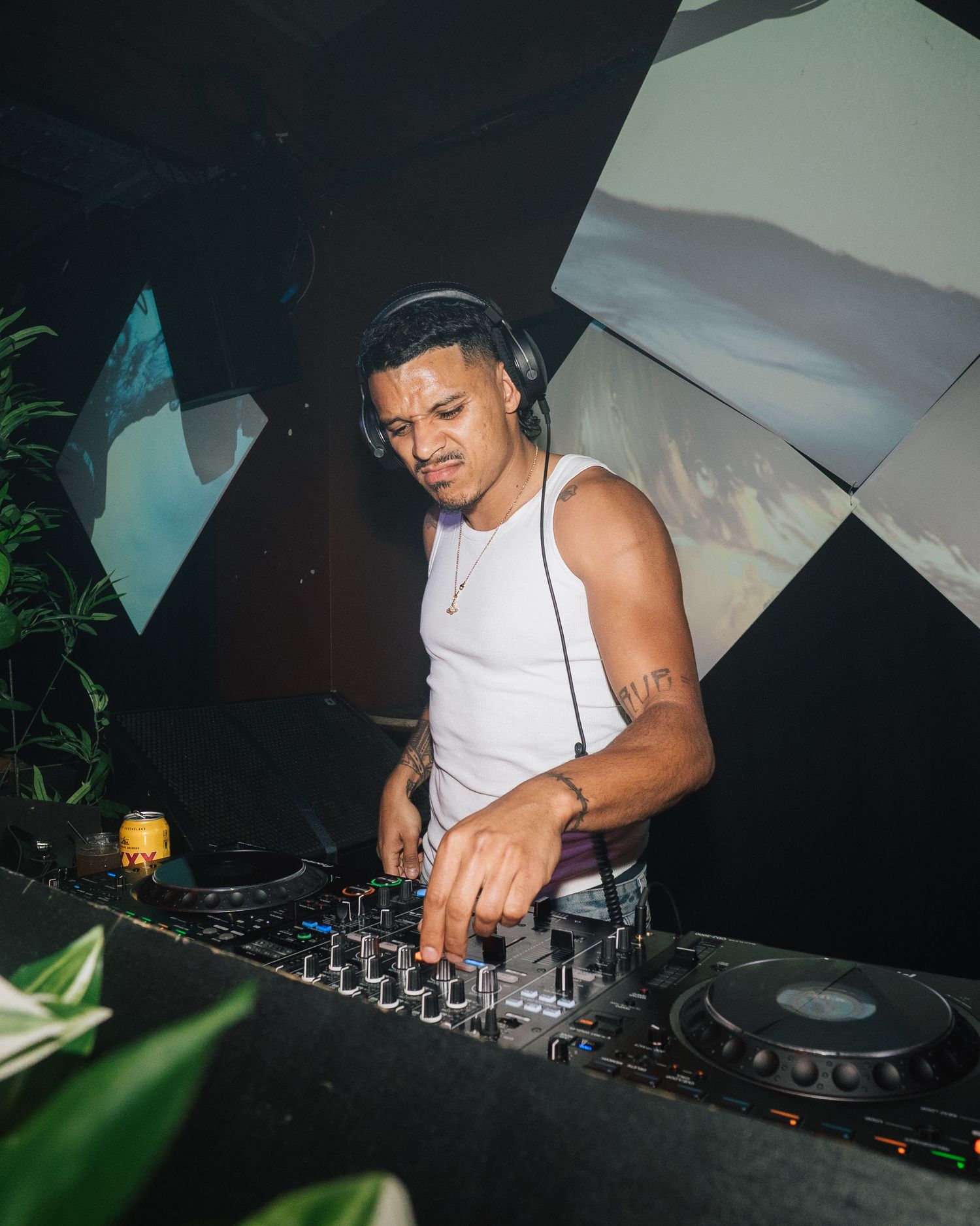 DJ mixing tracks at a club venue with modern equipment and ambient lighting.