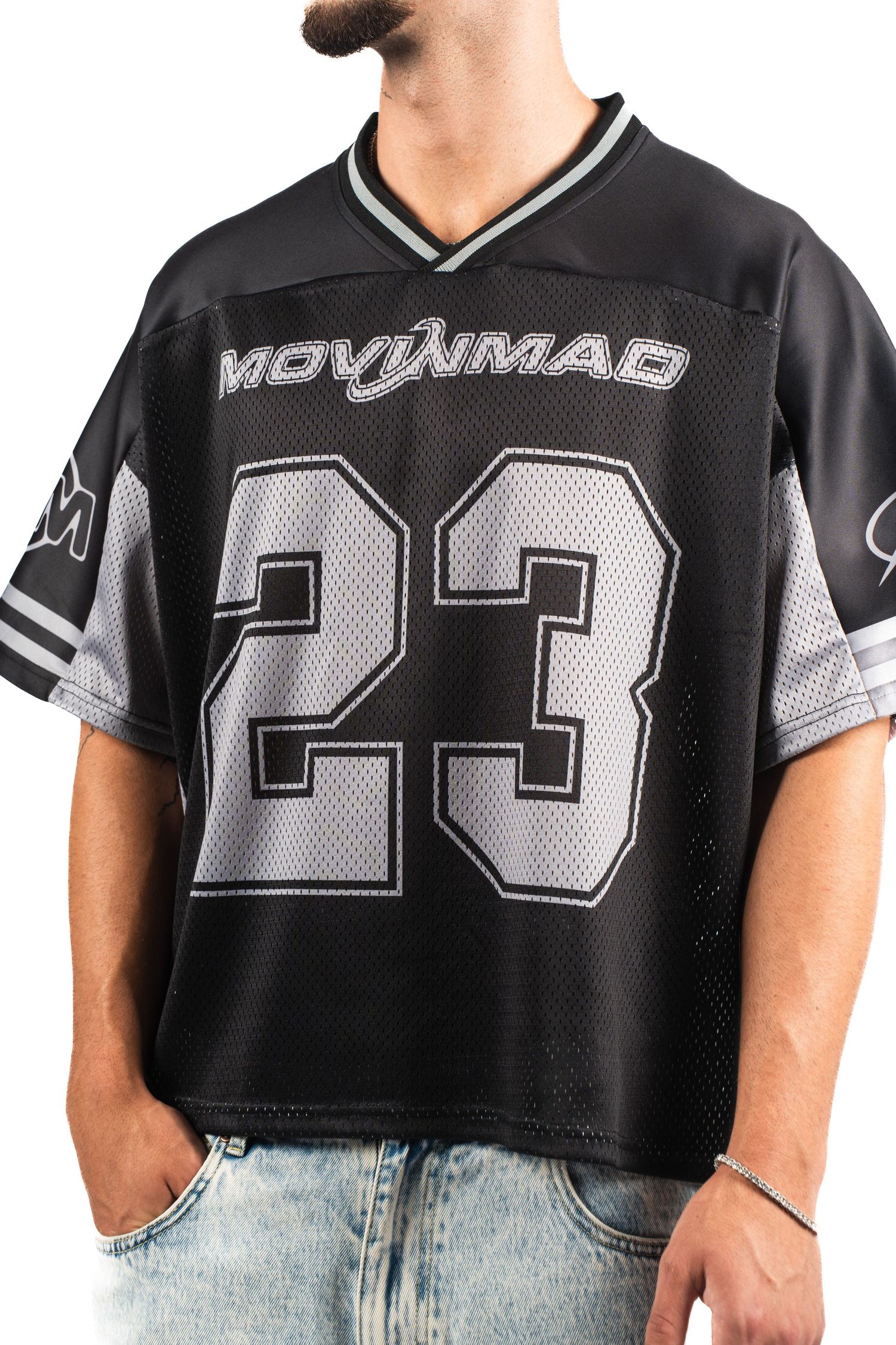 Close-up of black and gray sports jersey with number 23 against light background.