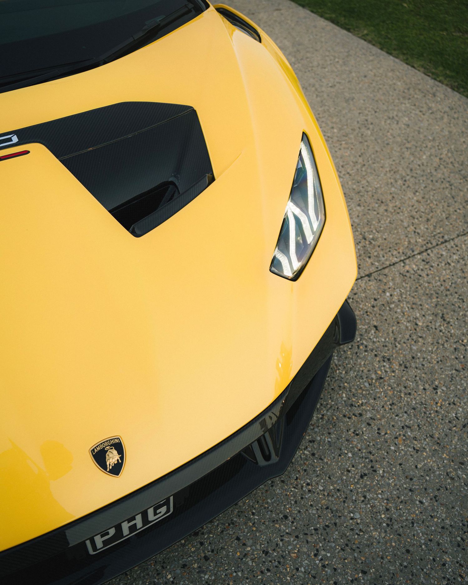 Close-up detail of yellow Lamborghini hood with black air intake vent.