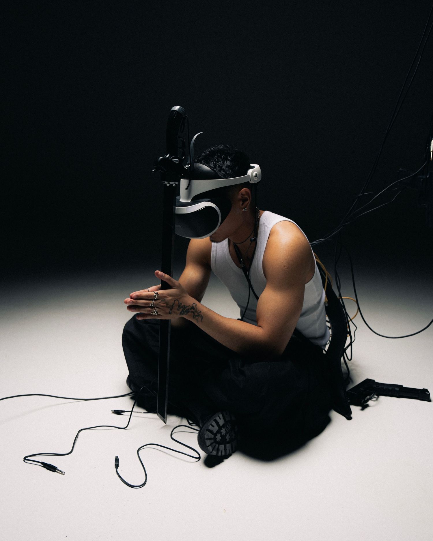 A person wearing a VR headset lies on the floor in a dark room with dramatic lighting creating an artistic silhouette.