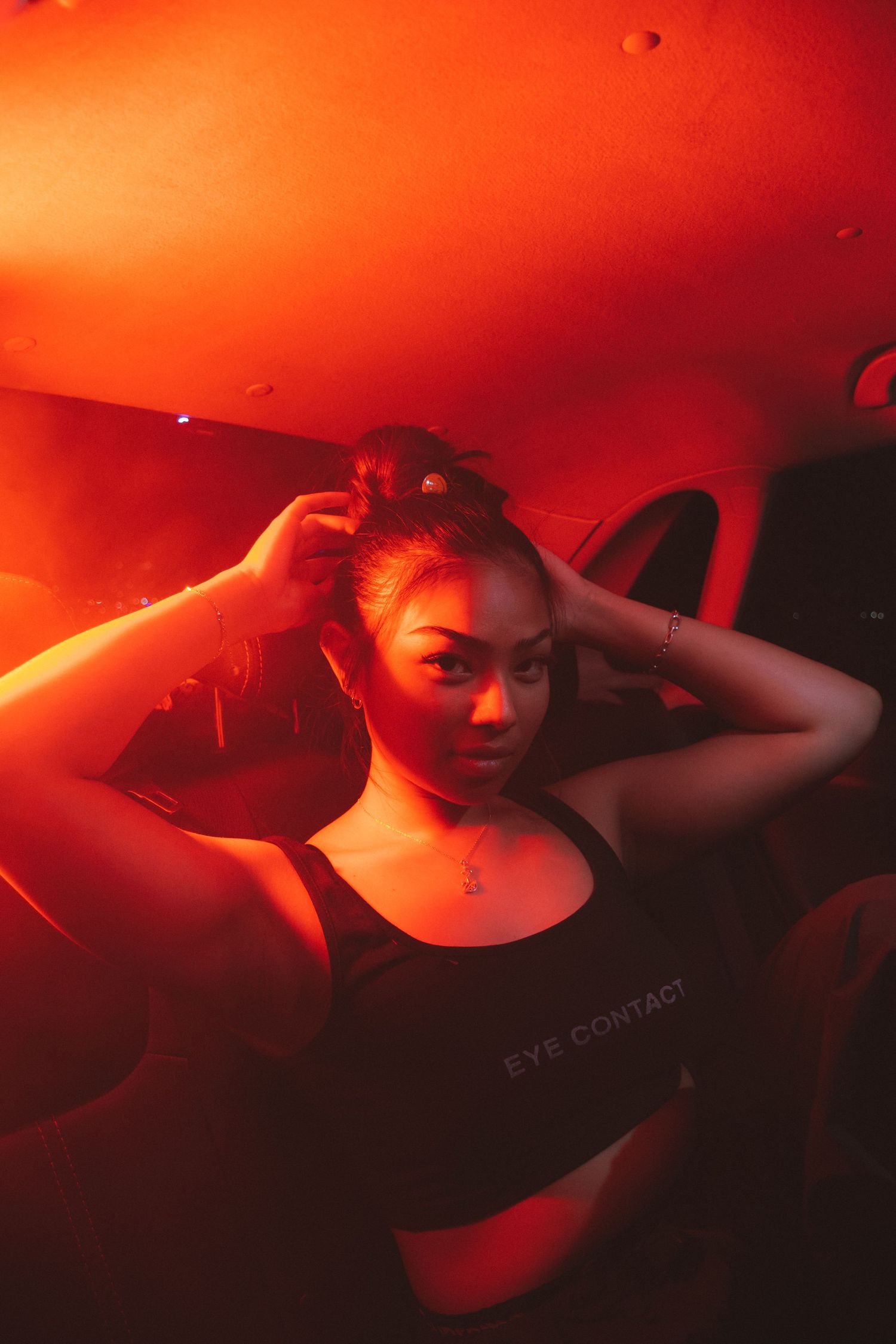 Portrait bathed in vibrant red lighting creating atmospheric mood.