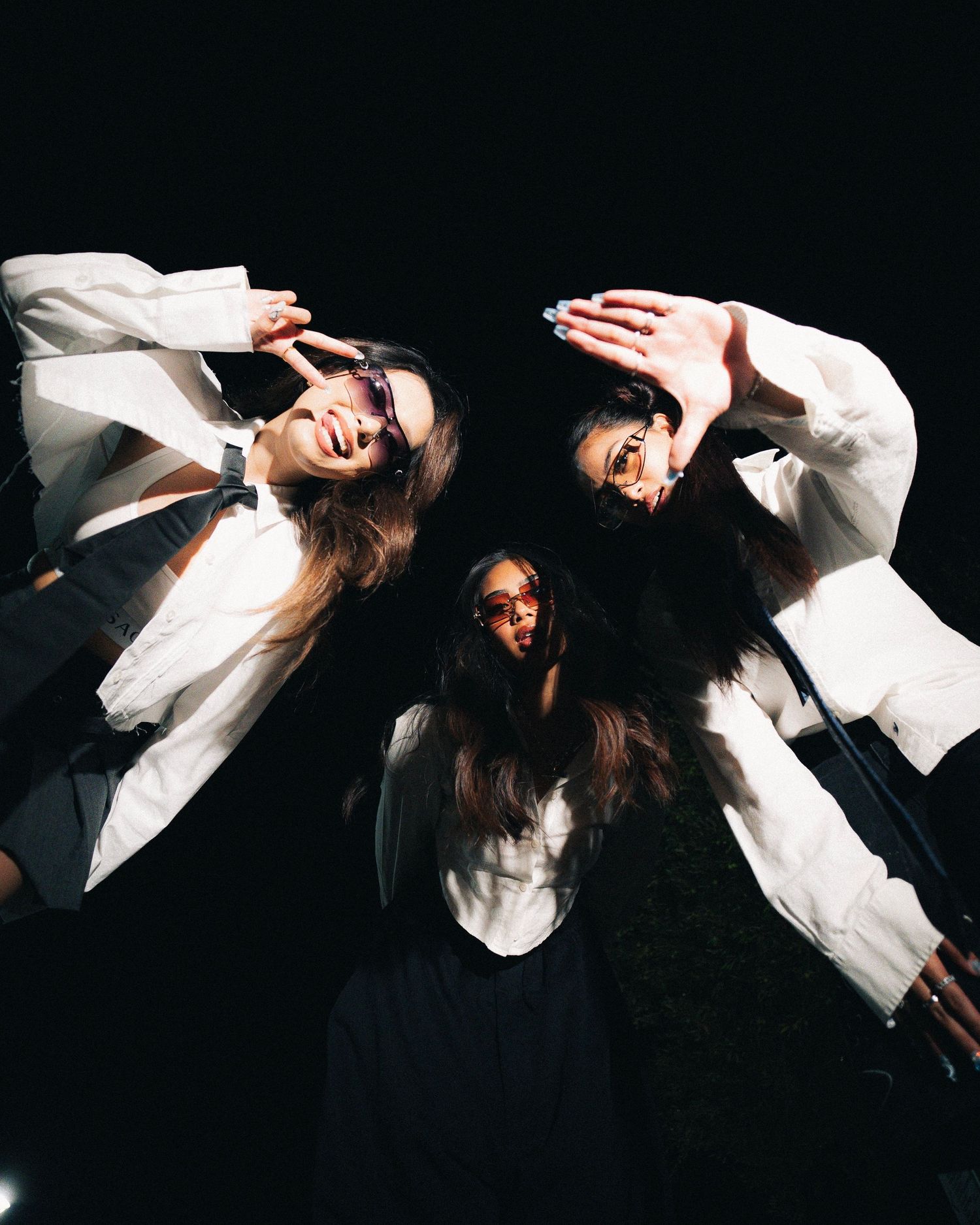 Artistic photo composition showing three poses in white outfits against dark background.