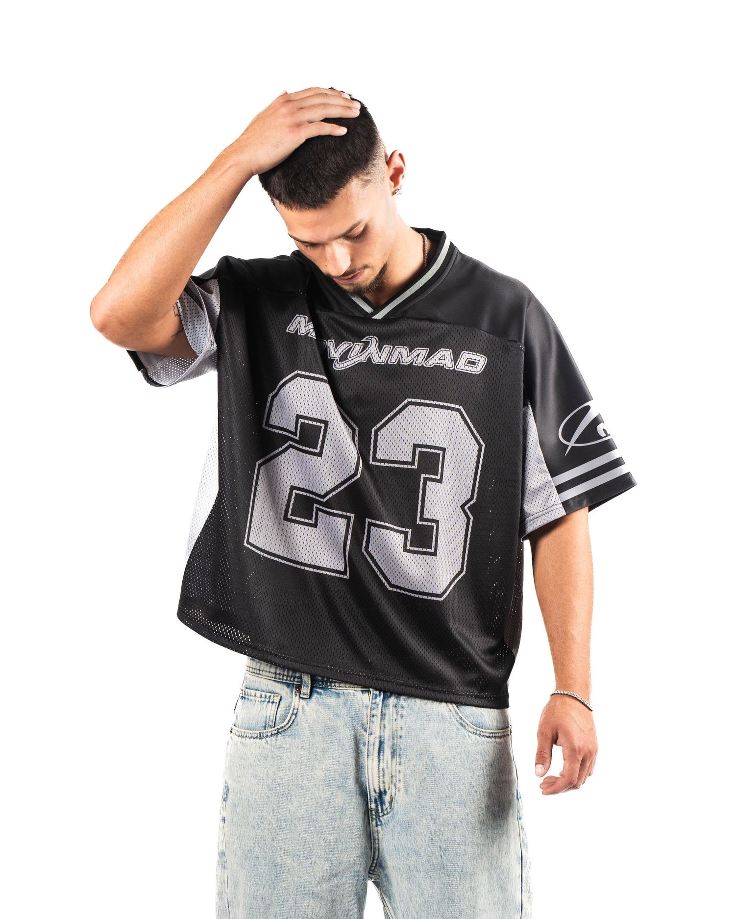 Person wearing black sports jersey with number 23 and light wash jeans.