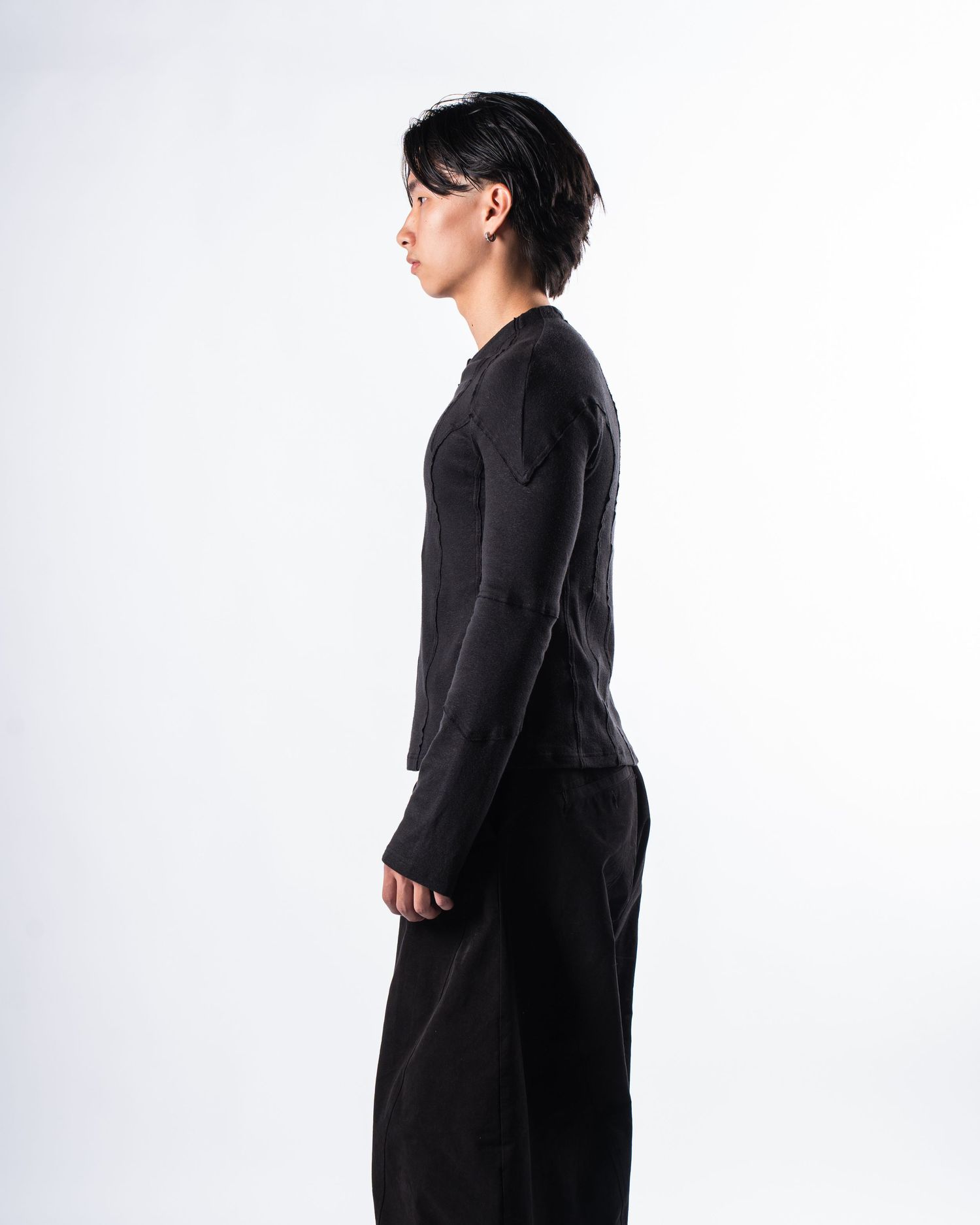 Person wearing glasses and a black top stands in three different poses against a white background.