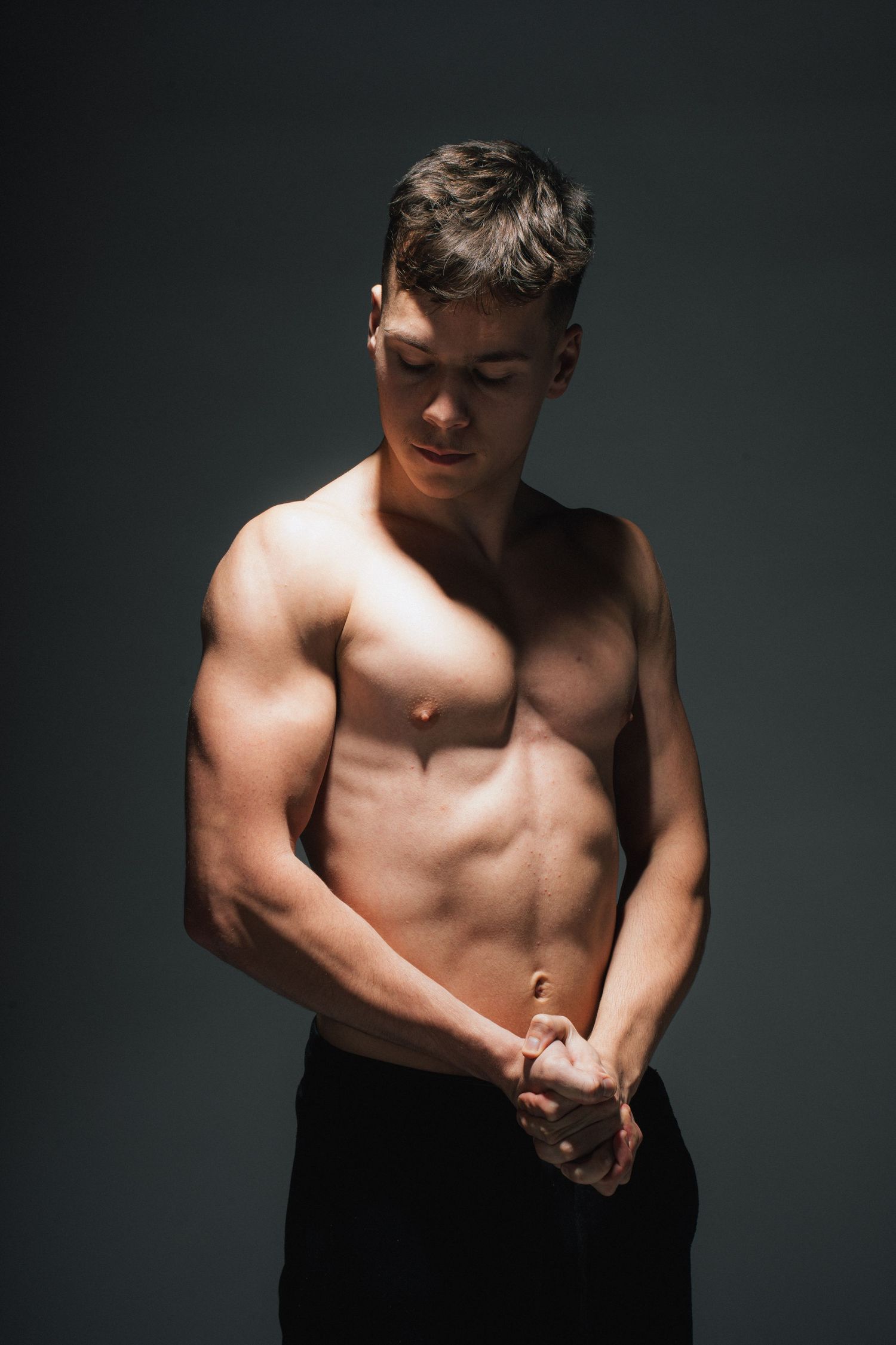 A dramatic series of black and white photographs showing a muscular shirtless torso against a dark background.