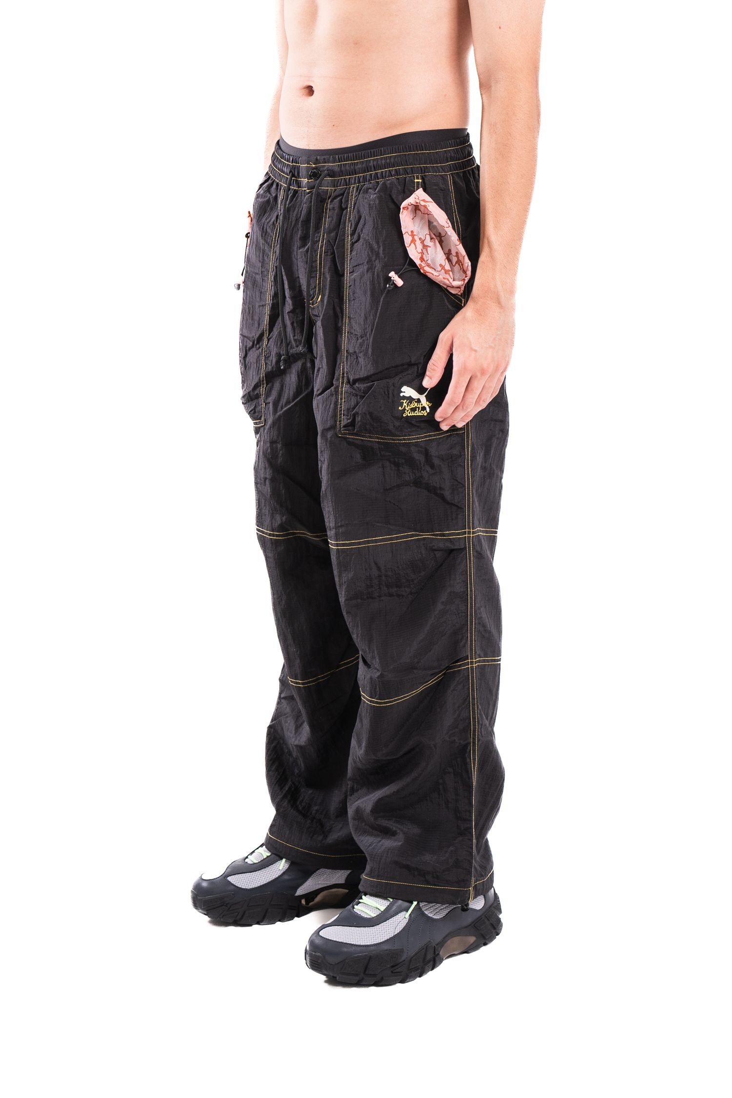 Black utility cargo pants with contrast stitching shown on model.