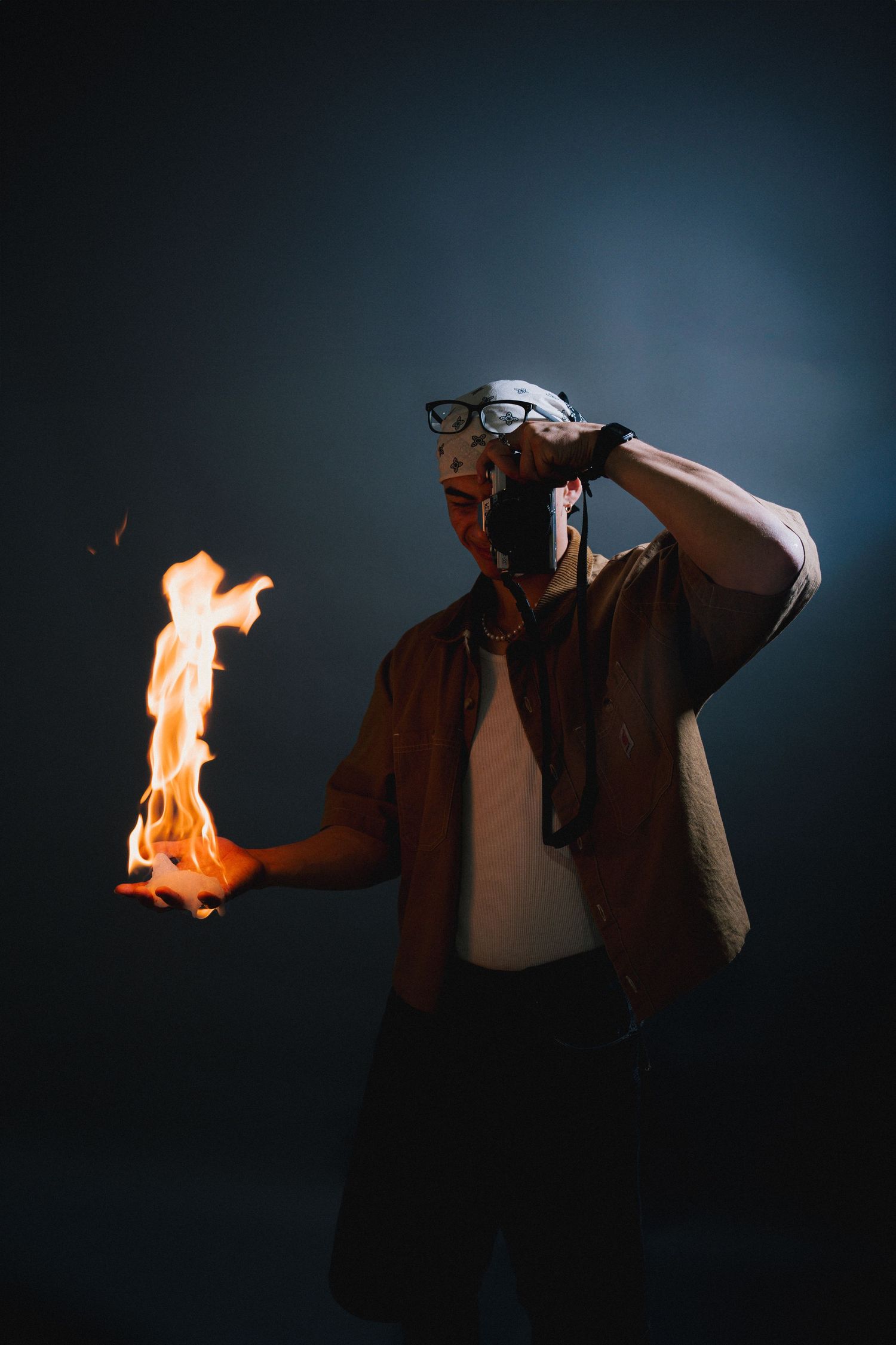A dramatic sequence showing a leather-clad figure with burning fire in hand against a dark moody background.