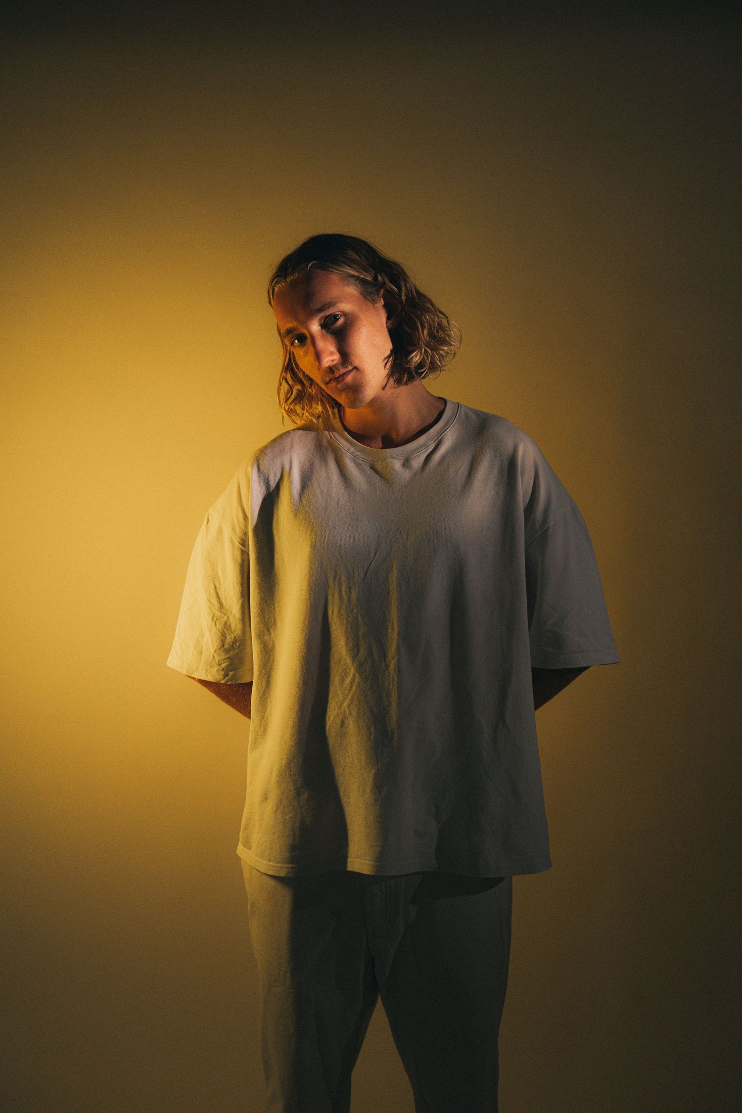 A moody portrait sequence shows a person in a white t-shirt against a golden-lit background.