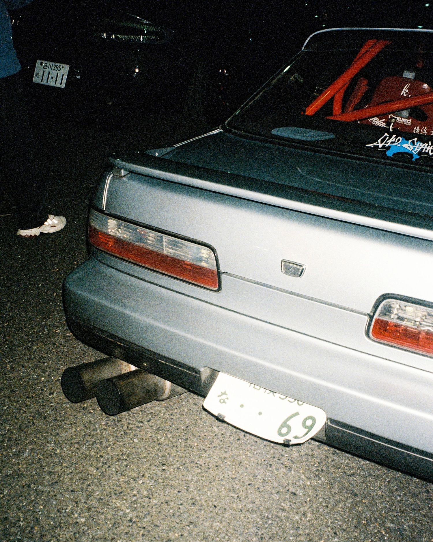 Rear detail of silver Honda Civic showing custom dual exhaust setup.