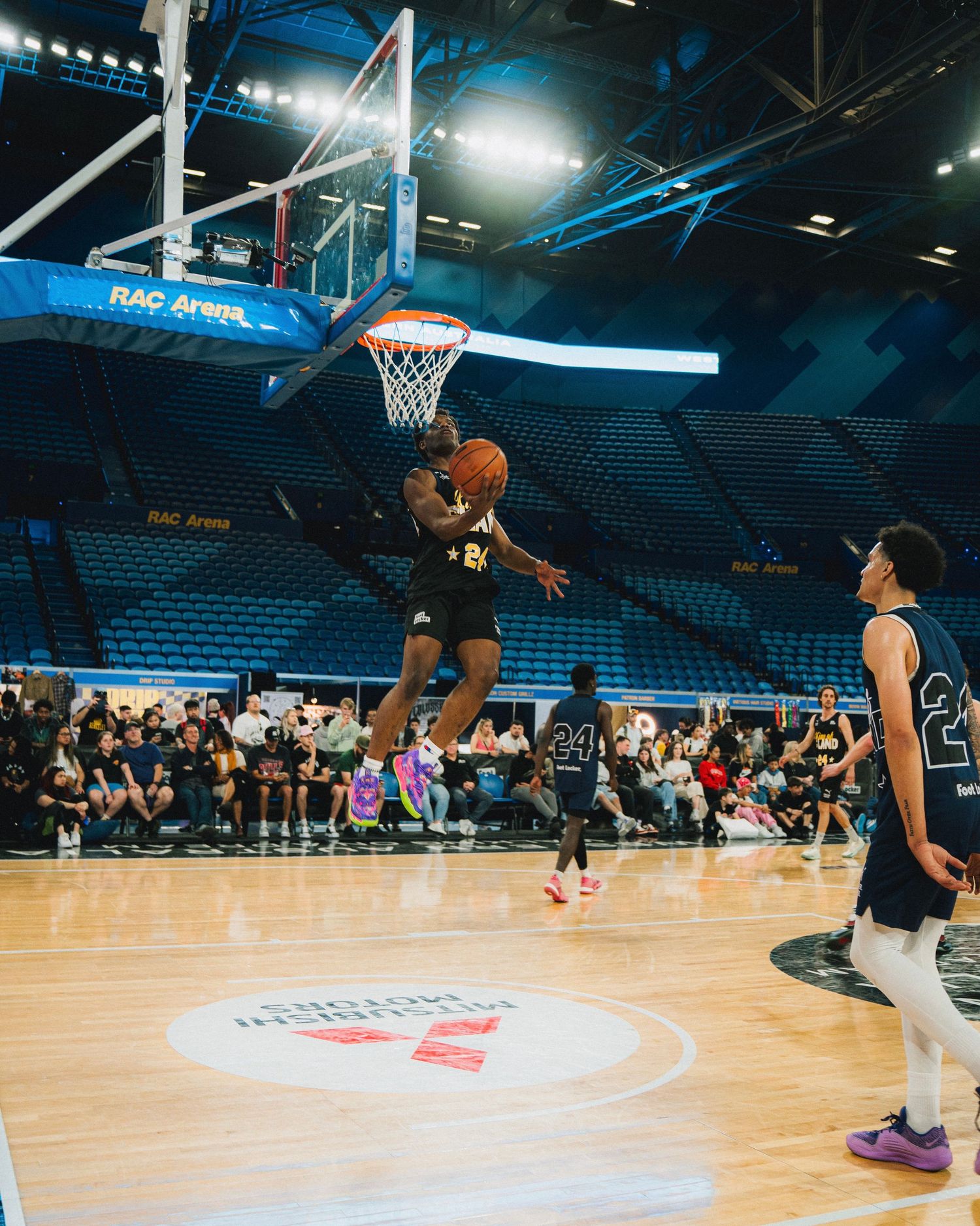 Player drives to the basket for a layup during basketball game in indoor arena.