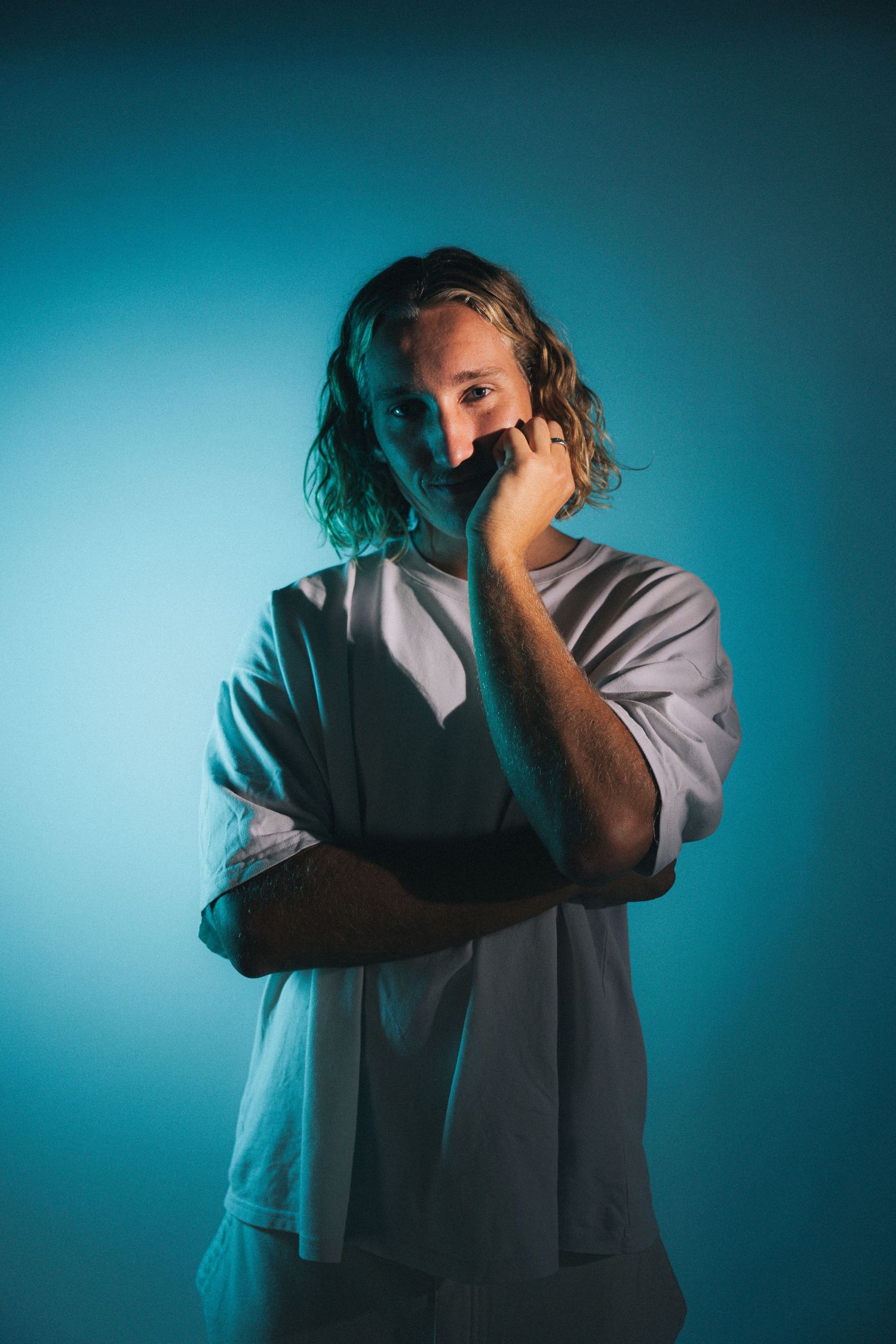 Artistic sequence showing figure in grey sweater against teal background expressing emotional distress in dramatic poses.