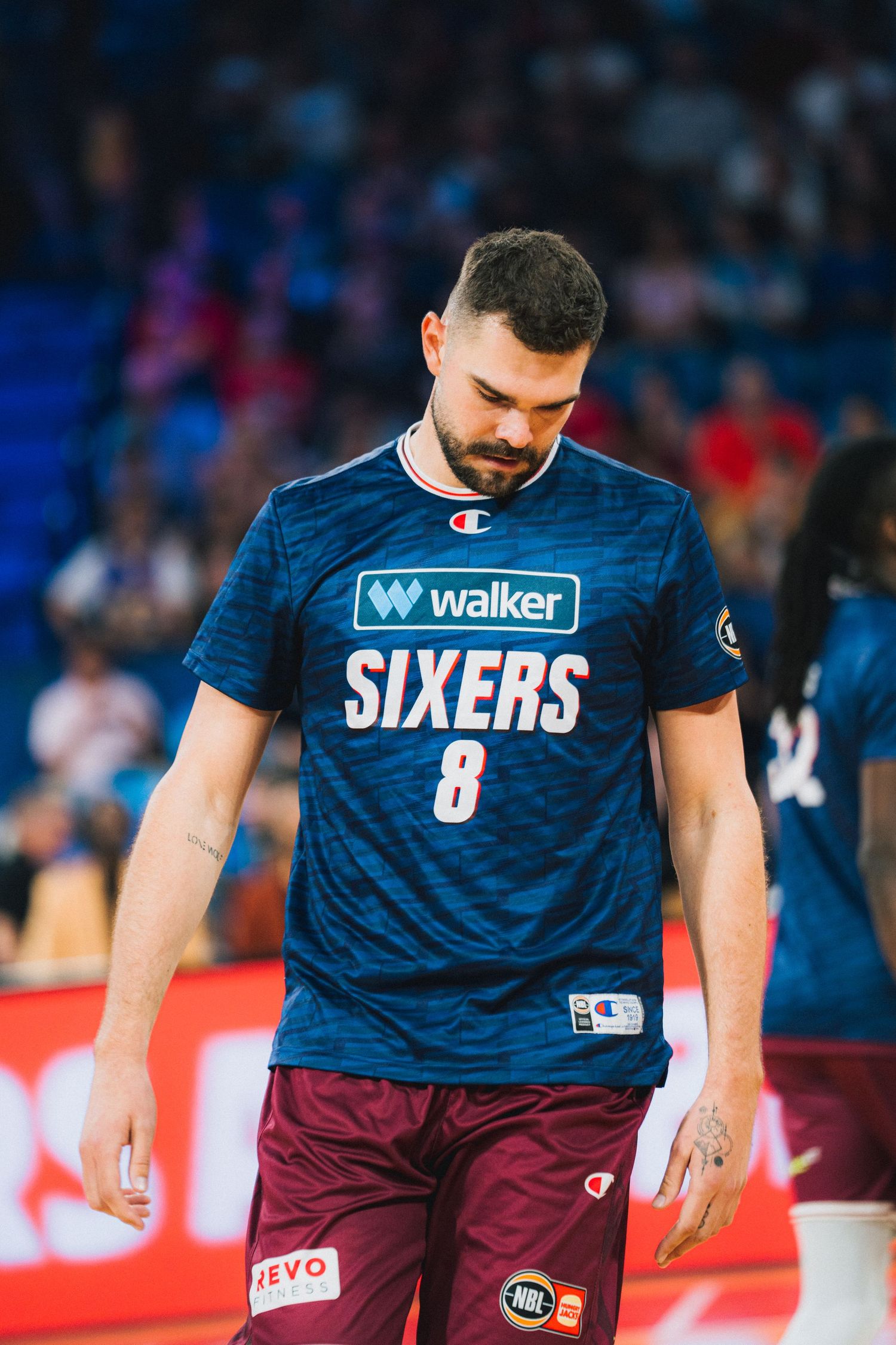 Basketball player wearing blue Sixers jersey number 8 during game.
