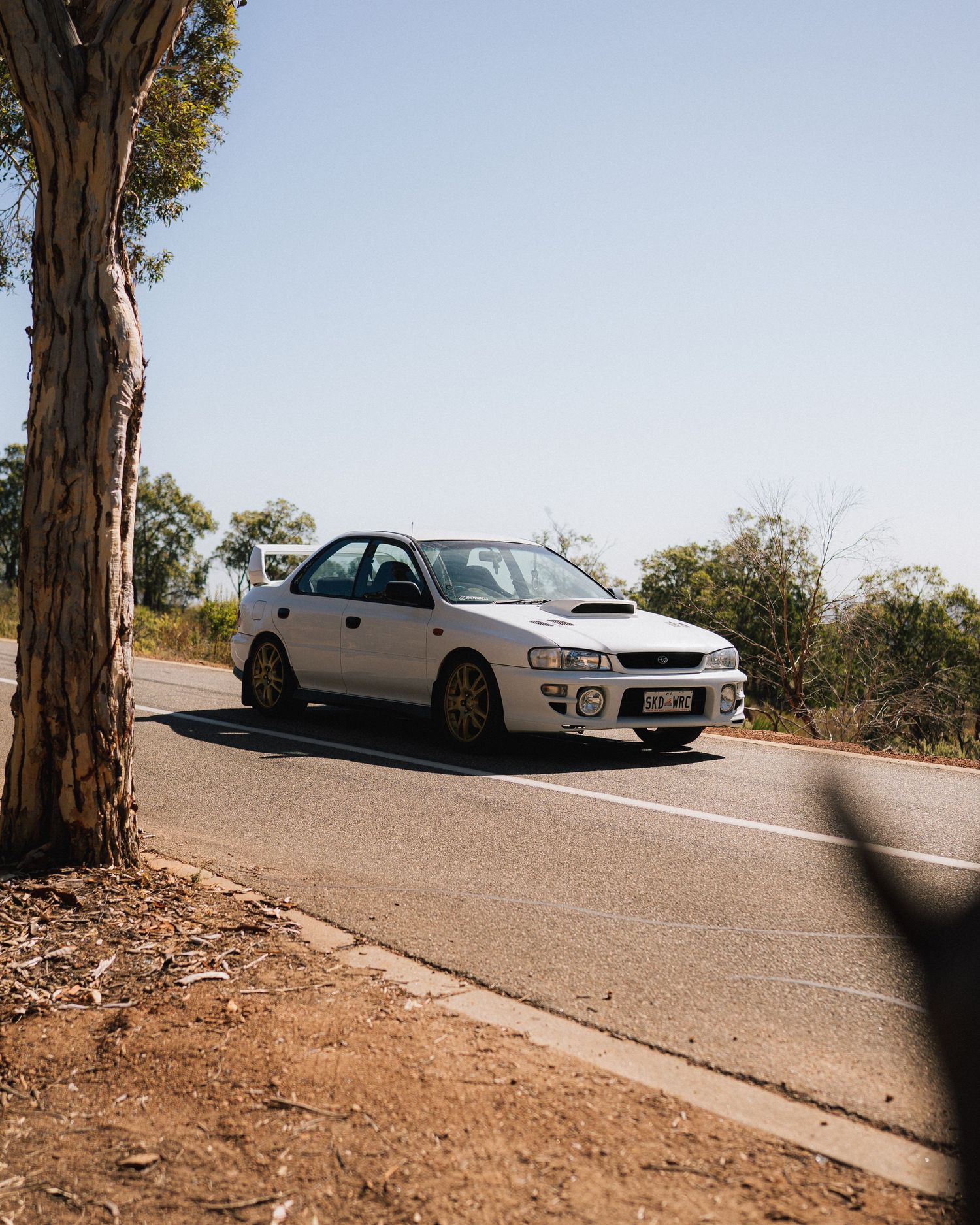 Silver Subaru WRX STI photographed on a sunny mountain road.