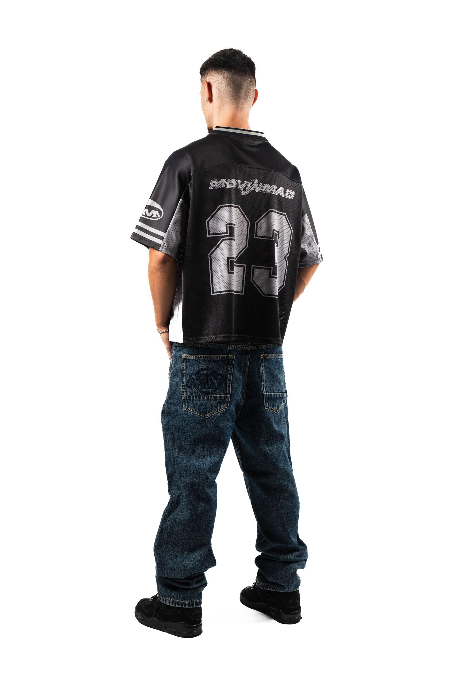 Back view of black sports jersey with number 23 and blue jeans.