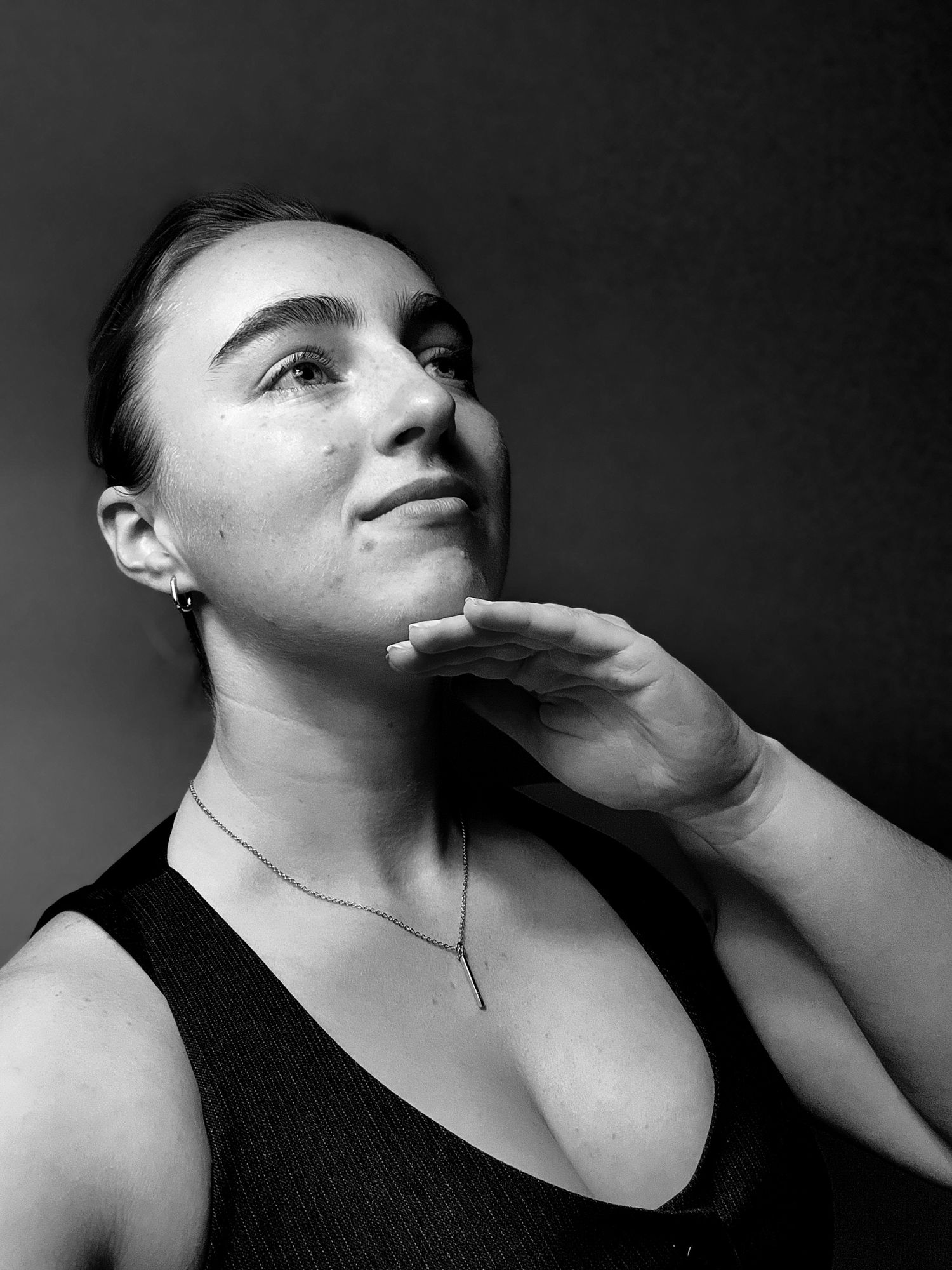 Dramatic black and white portrait series showing artistic poses against dark background.