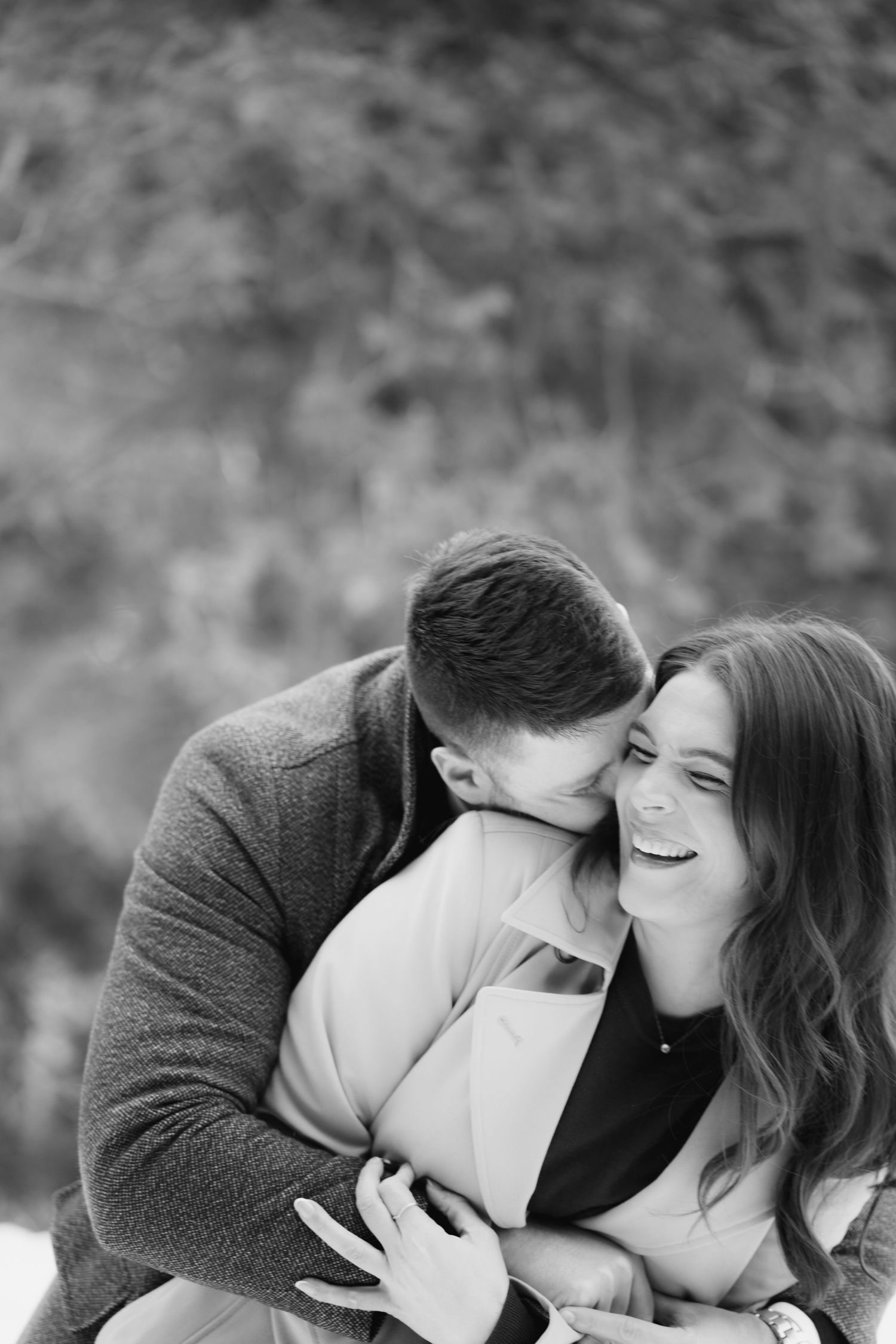Women laughs while man kisses her neck