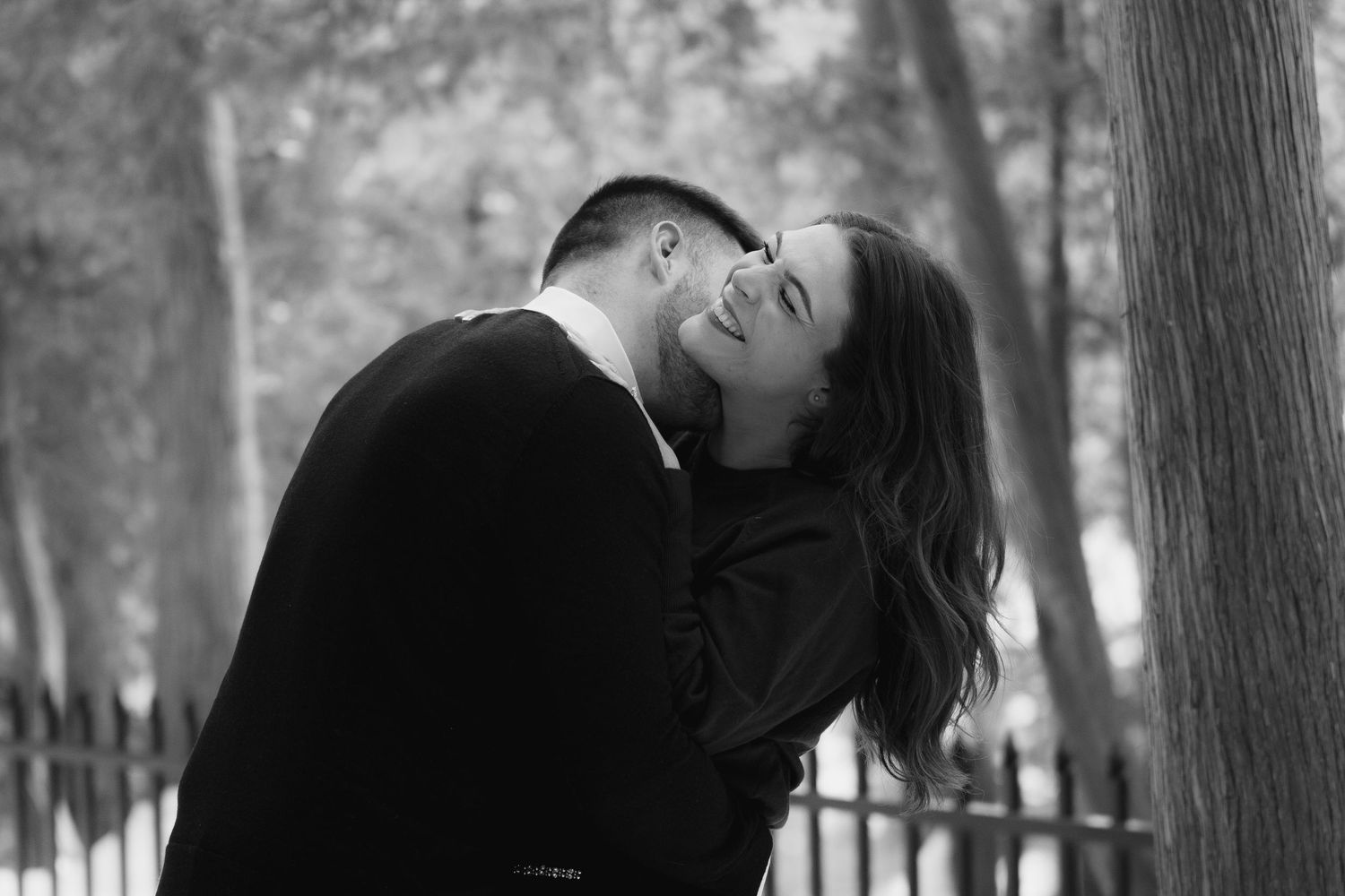 Women laughs while man kisses her neck