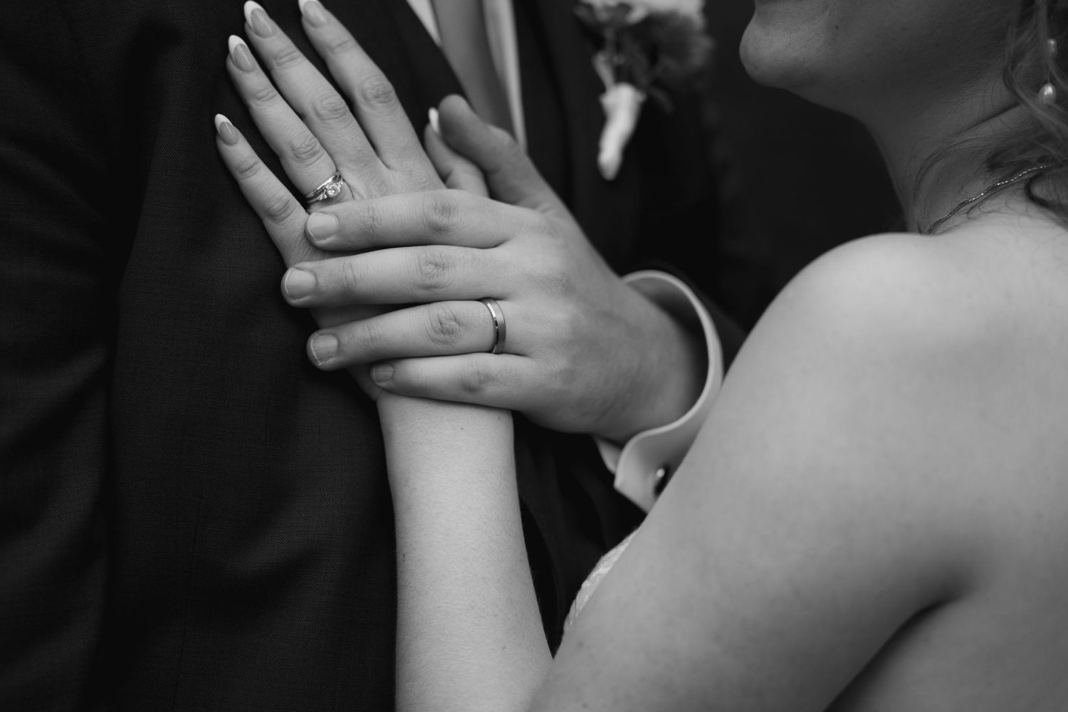 bride and groom holding hands with rings