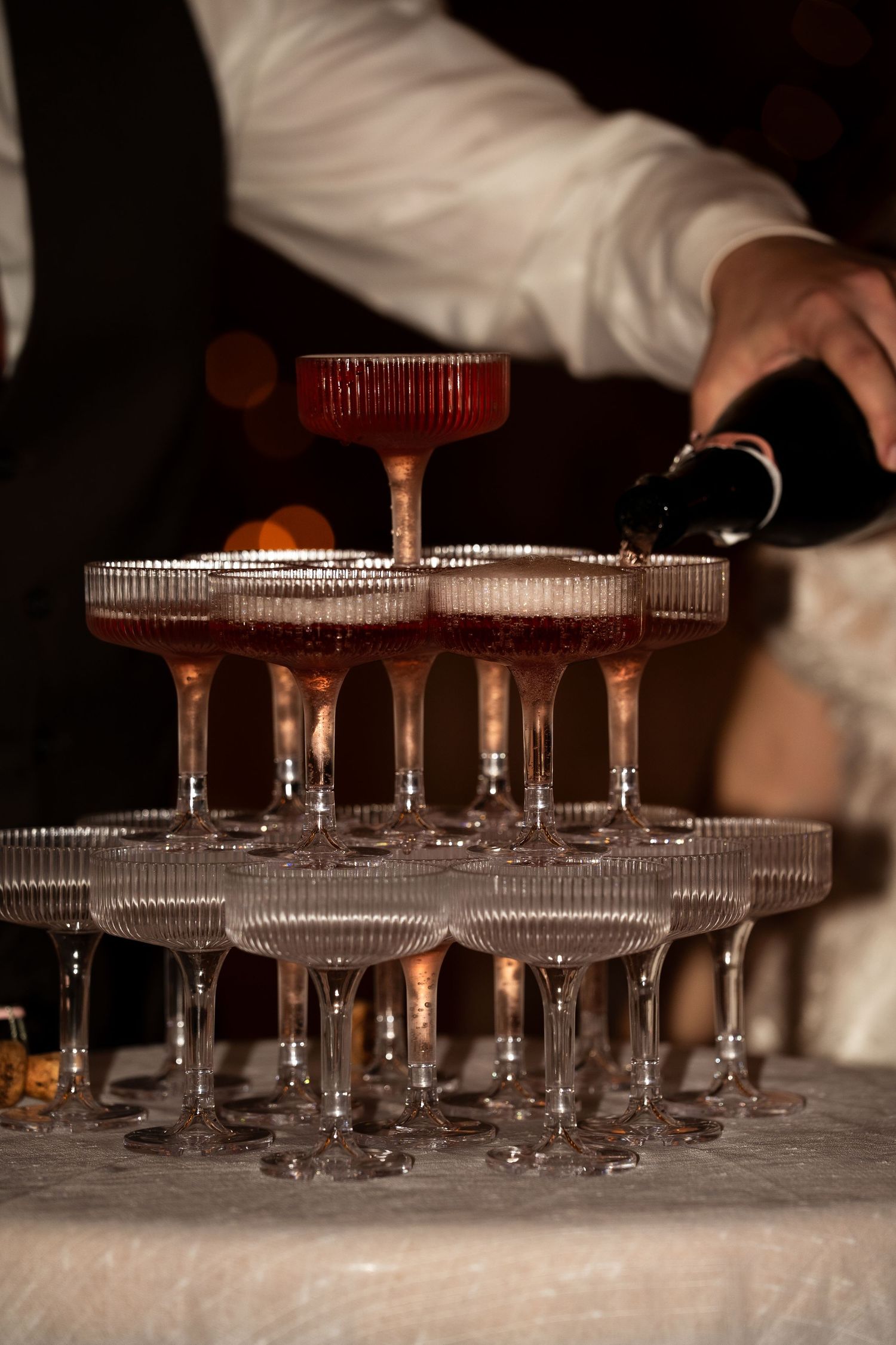 Close-up of groom pouring champagne