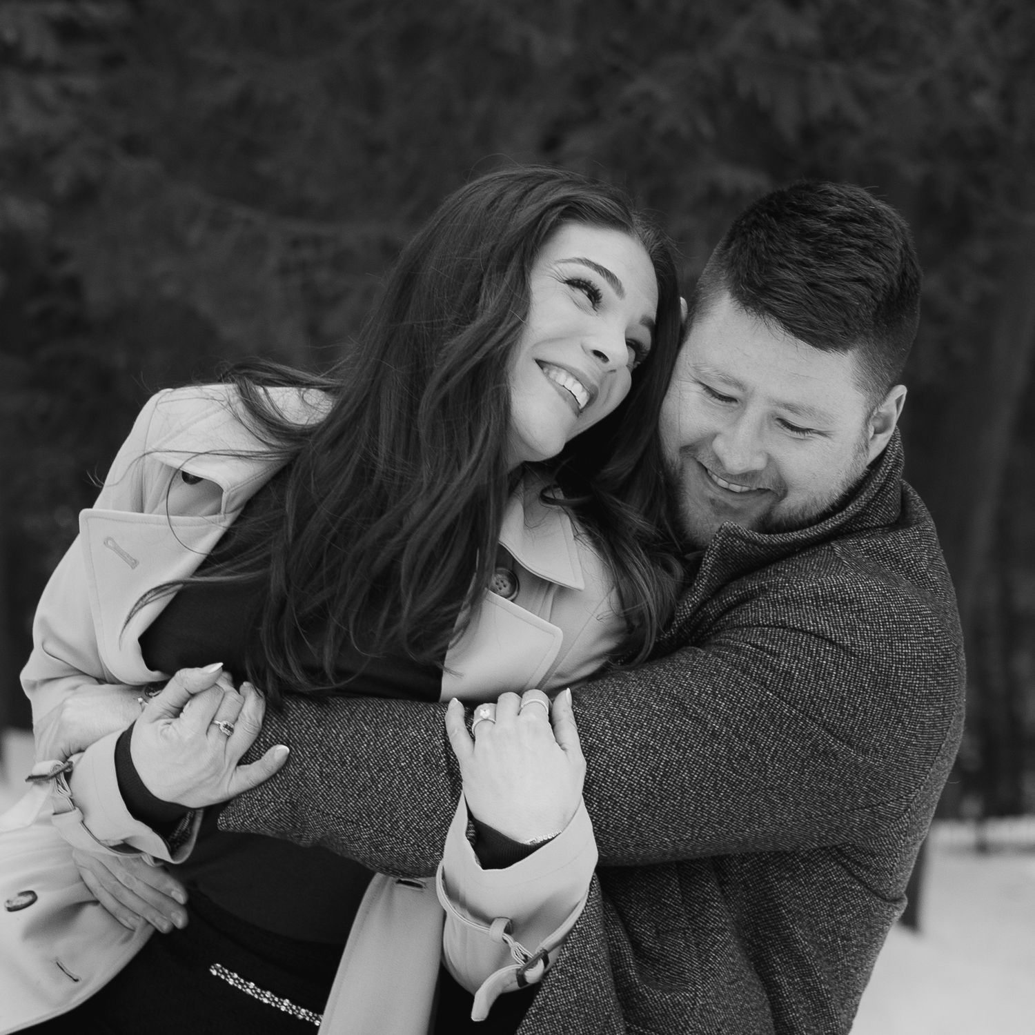 women smiles lovingly at man while he hugs her