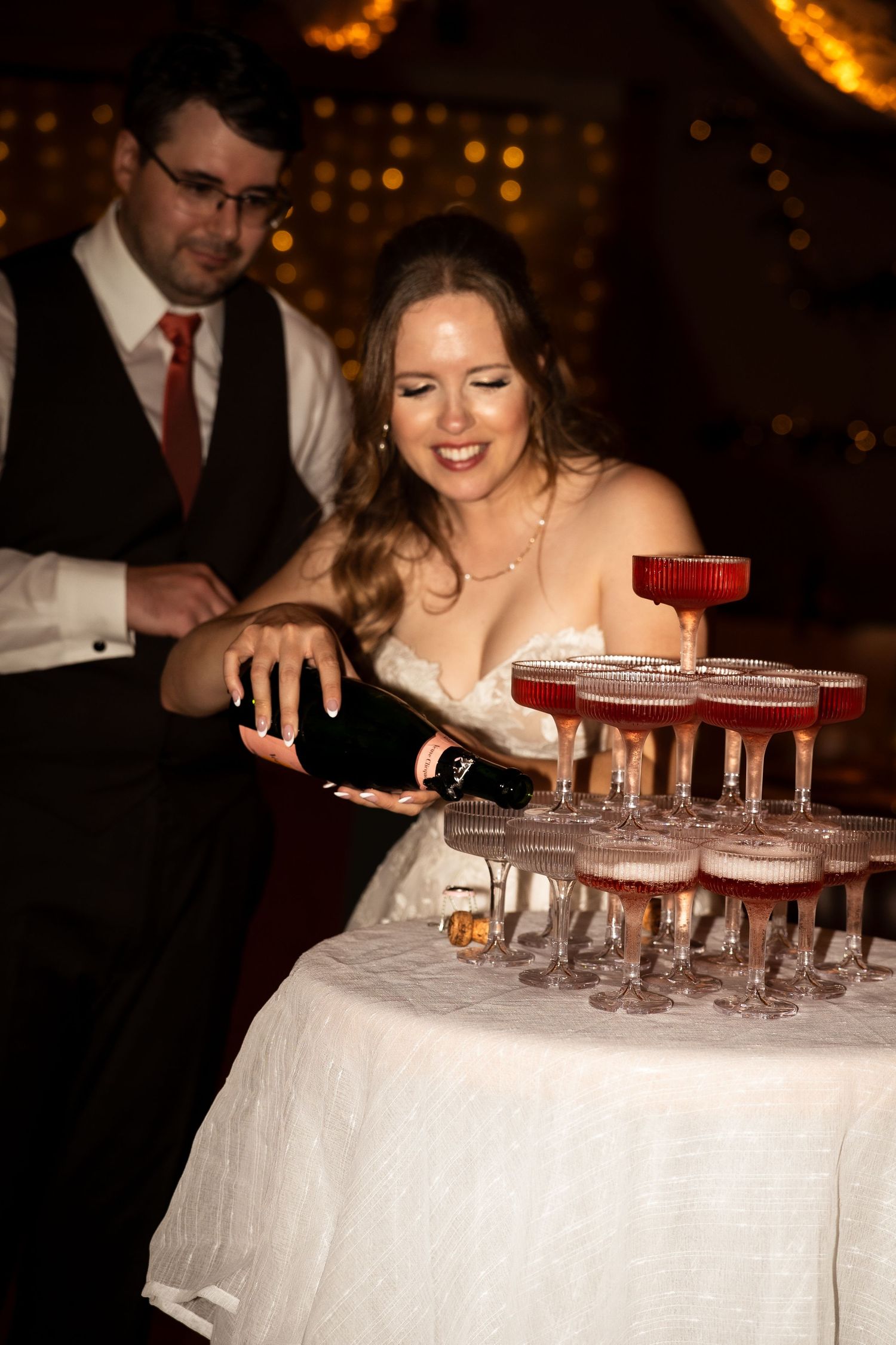 bride and groom pour champagne