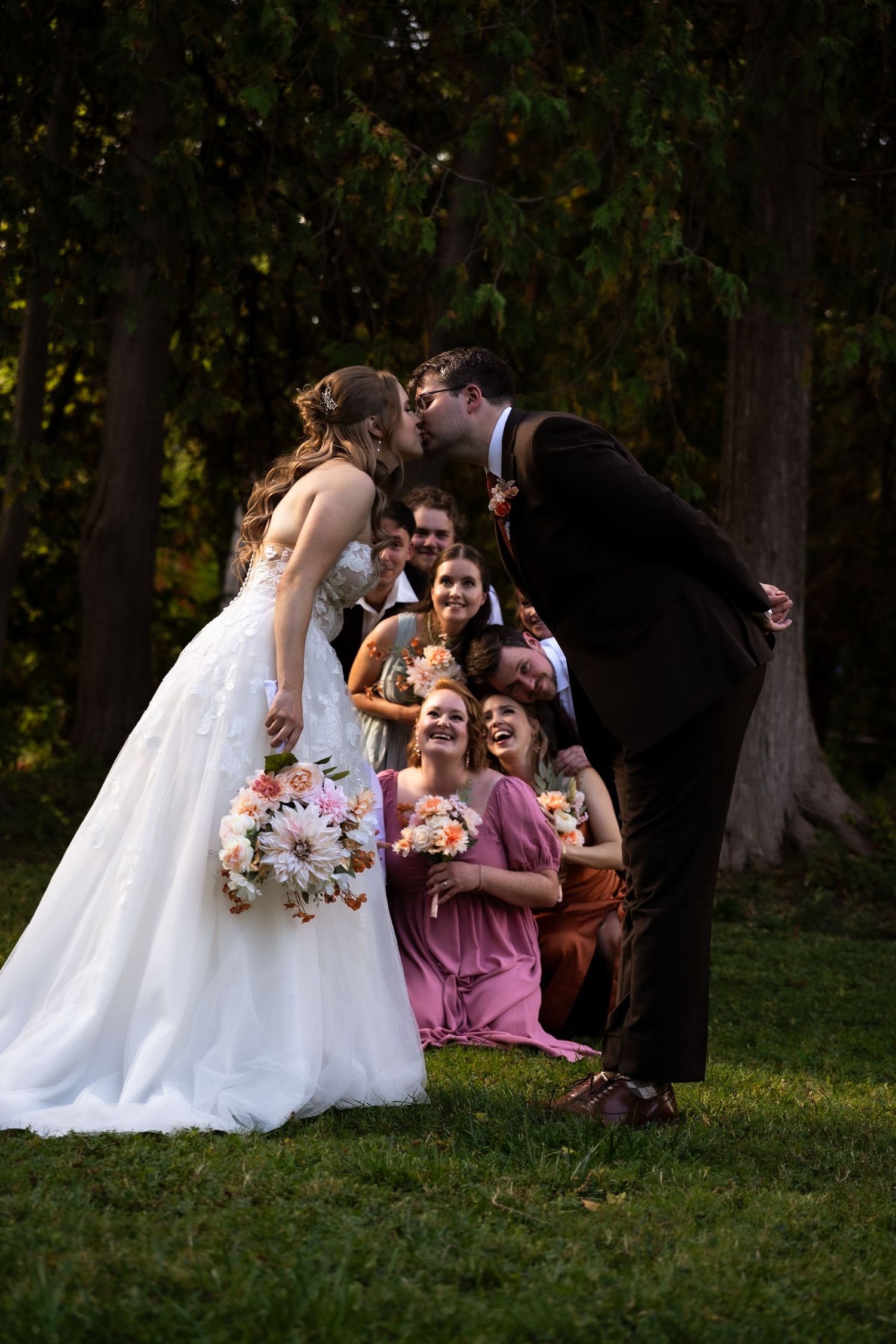 bride and groom kiss while bridal party cheers