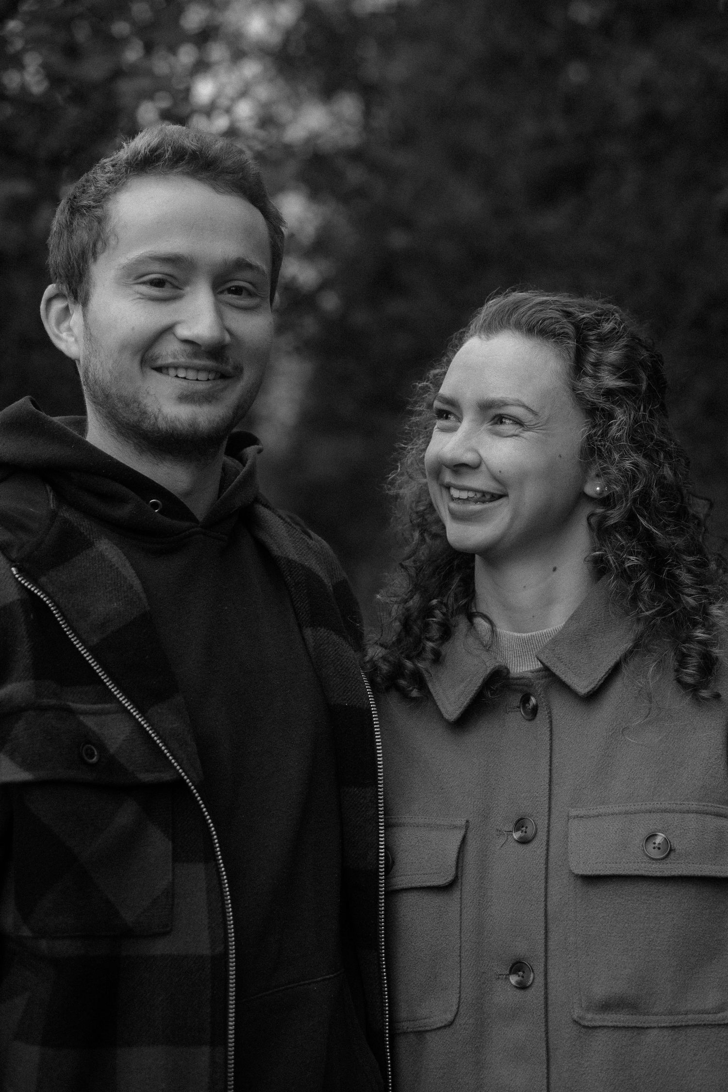 Black and white portrait series showing couple's joyful interactions outdoors.