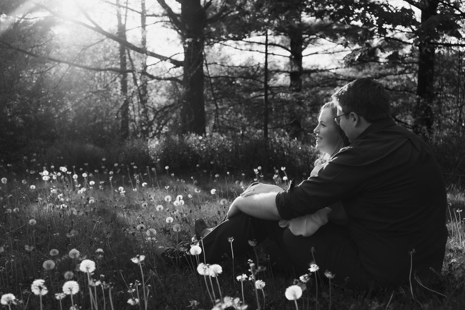 Dreamy black and white portraits in field of dandelions at dusk.