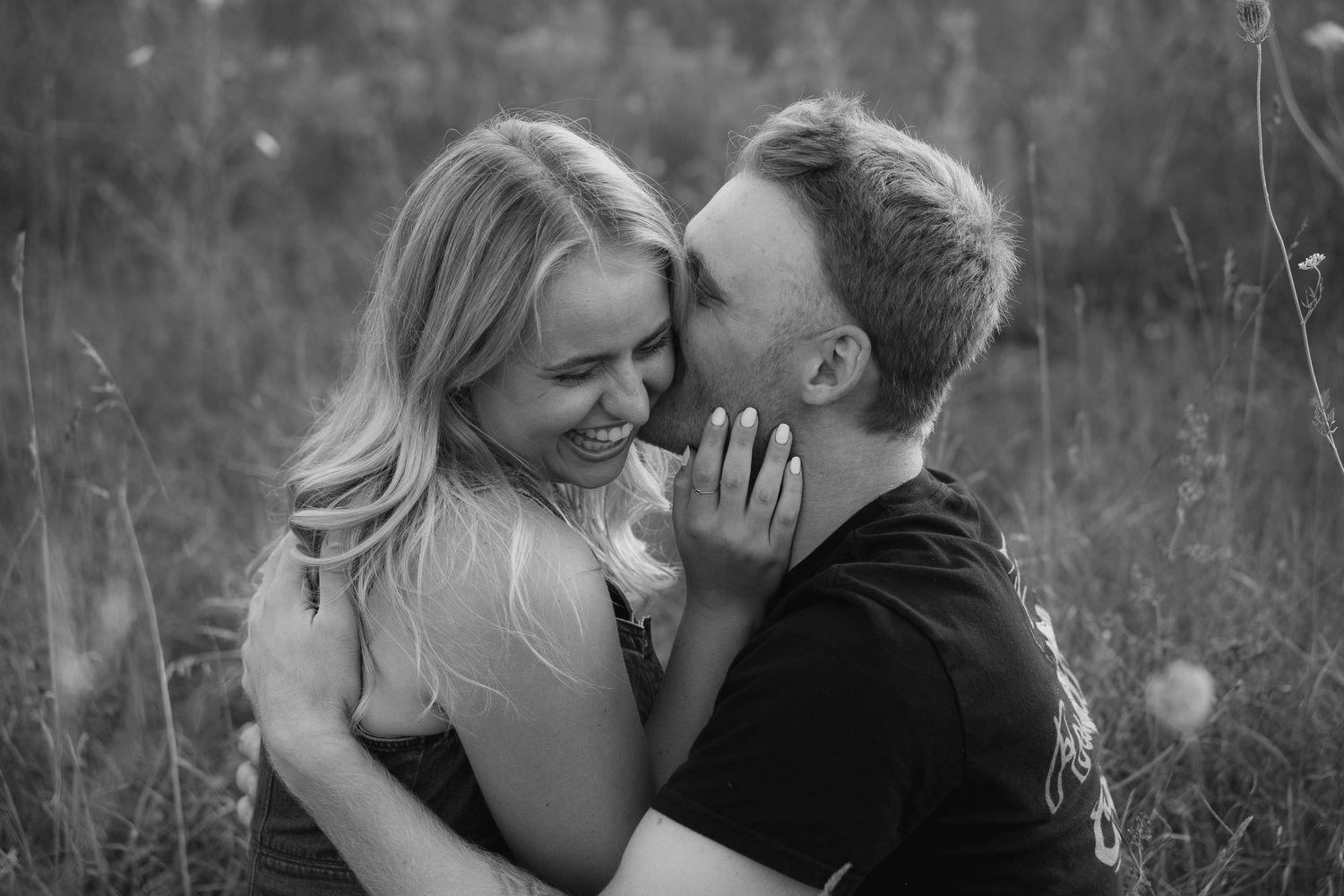 man kisses women on the cheek while she laughs