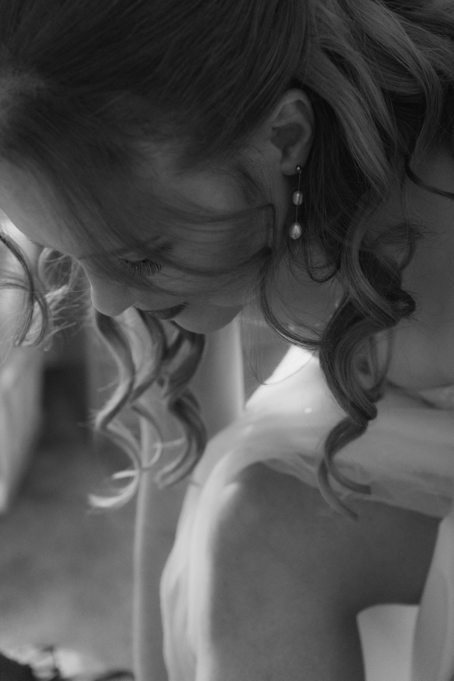 black and white of bride bending down to do up her shoe