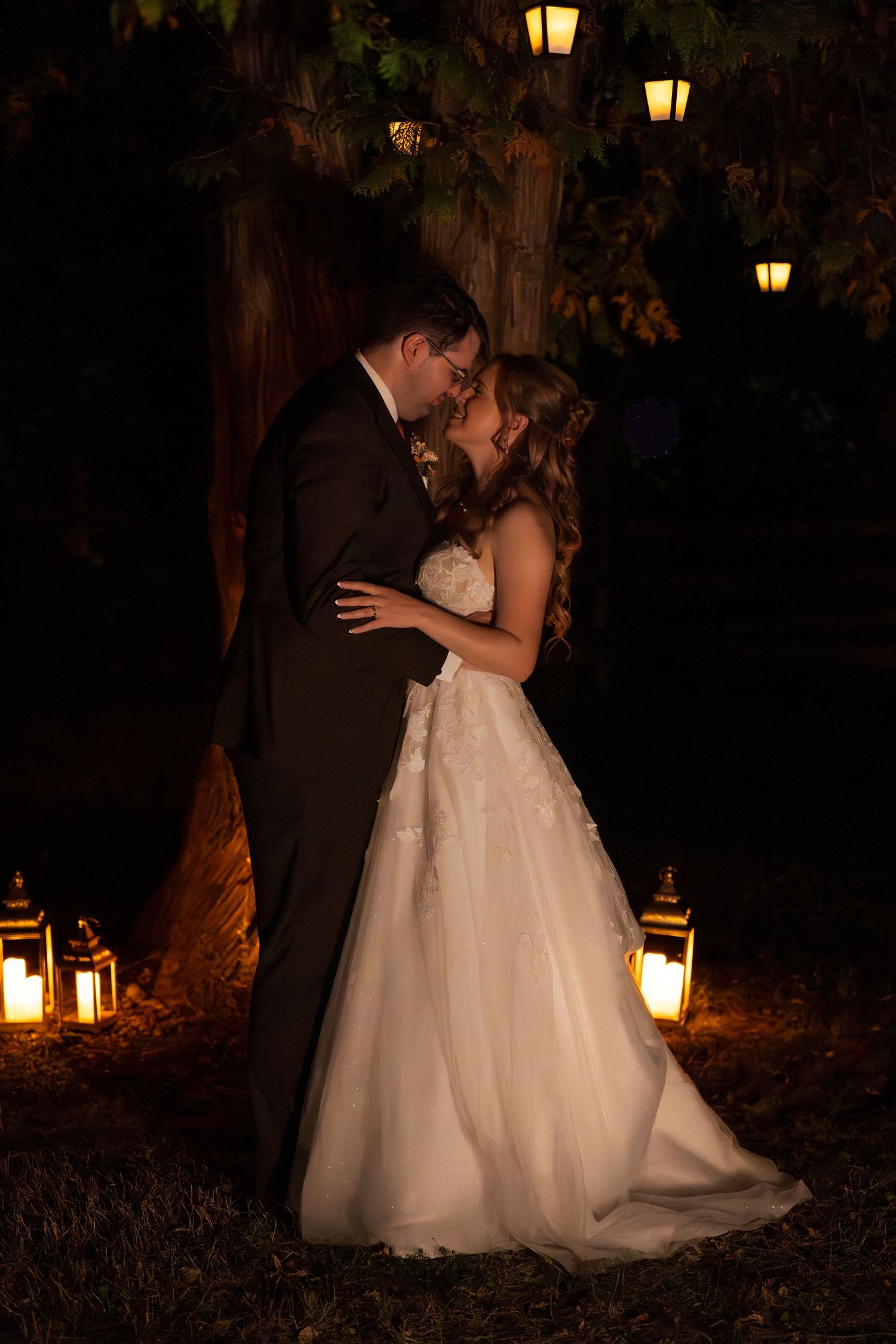 bride and groom kiss in lantern light