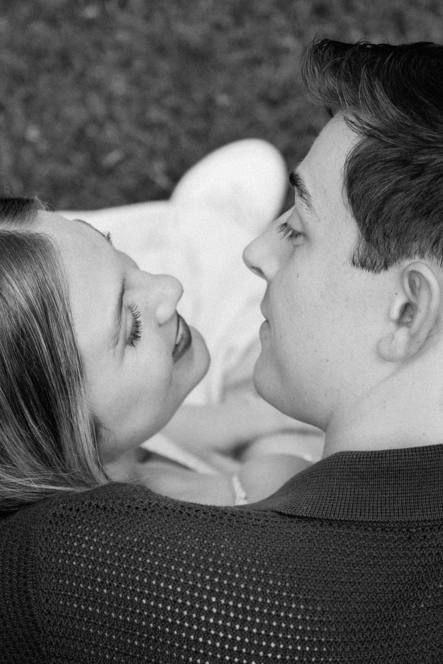 A romantic black and white close-up of a couple gazing at each other with tender affection.
