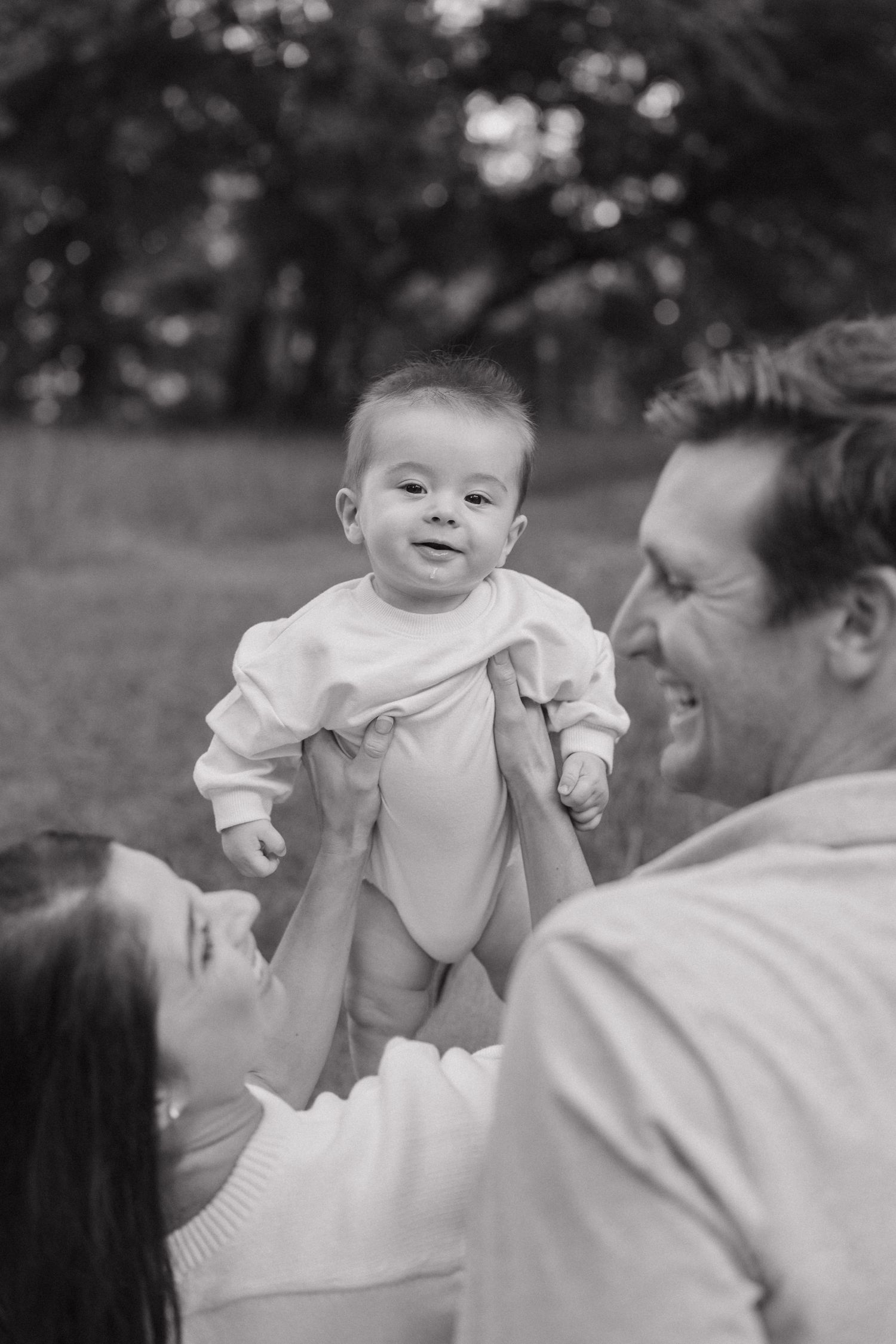 A heartwarming black and white sequence shows a baby and adult sharing joyful interactions and laughter.
