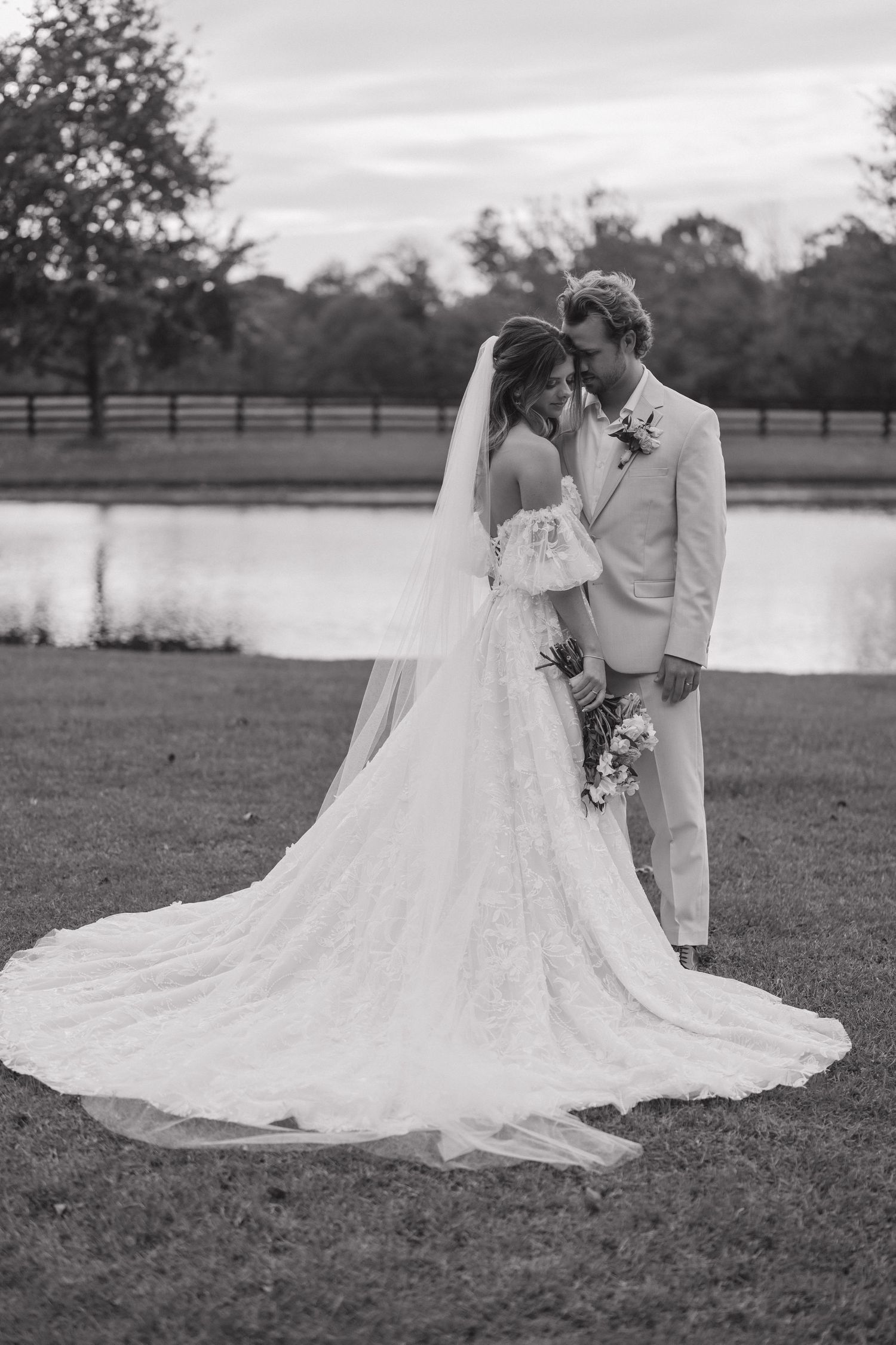 A romantic black and white wedding photo series showing a couple in an outdoor setting with a flowing white dress train.