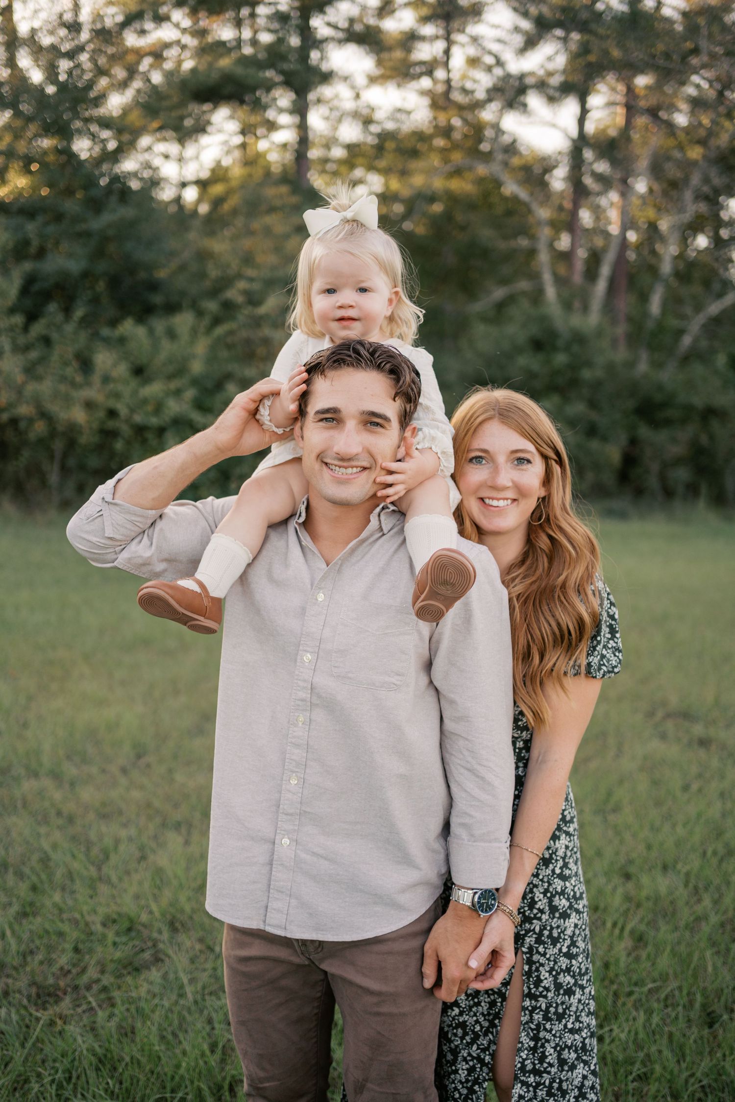 A group of candid outdoor portraits captured in a grassy field with trees at sunset.