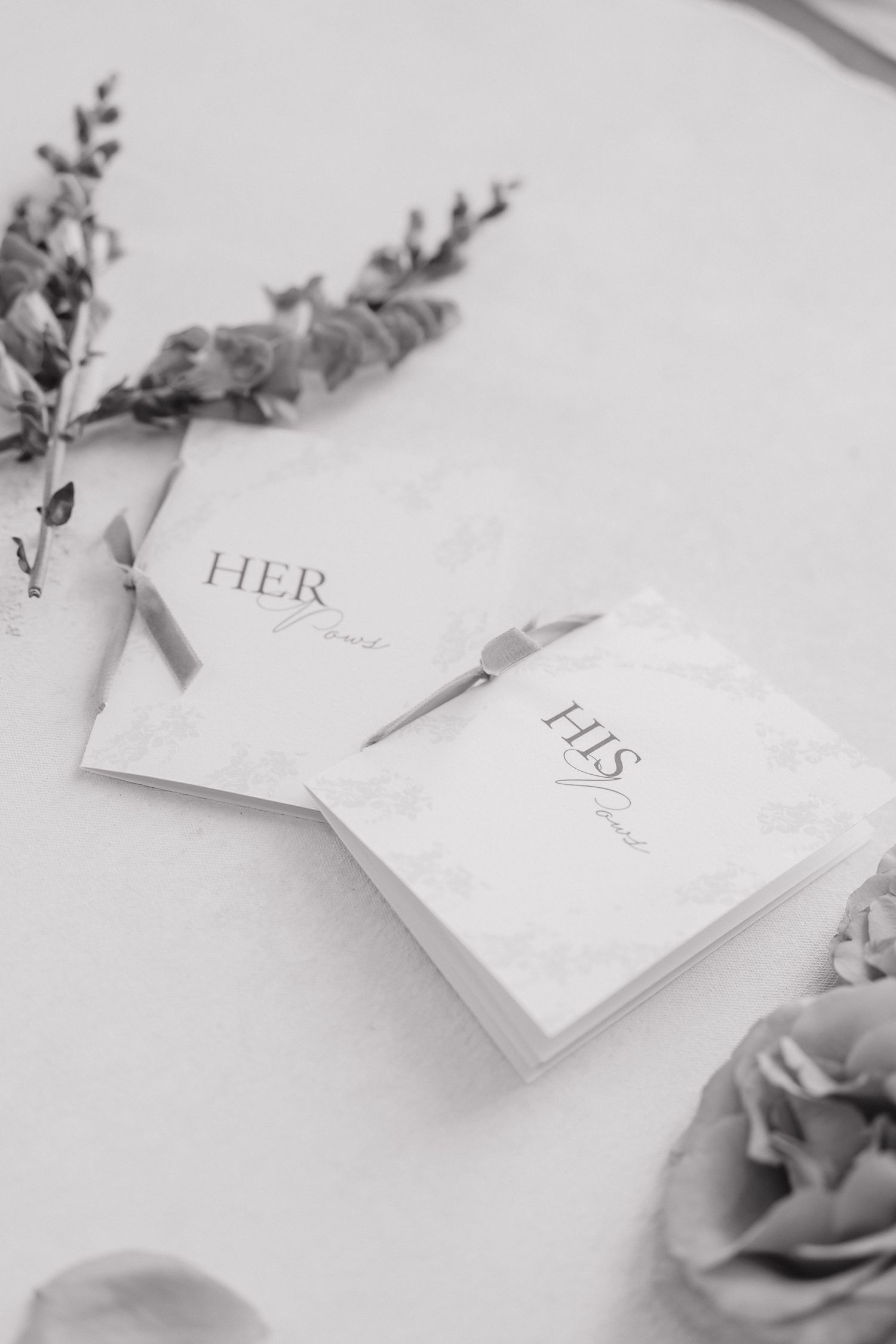 White business cards with floral elements arranged artistically on a light surface in a minimalist style.
