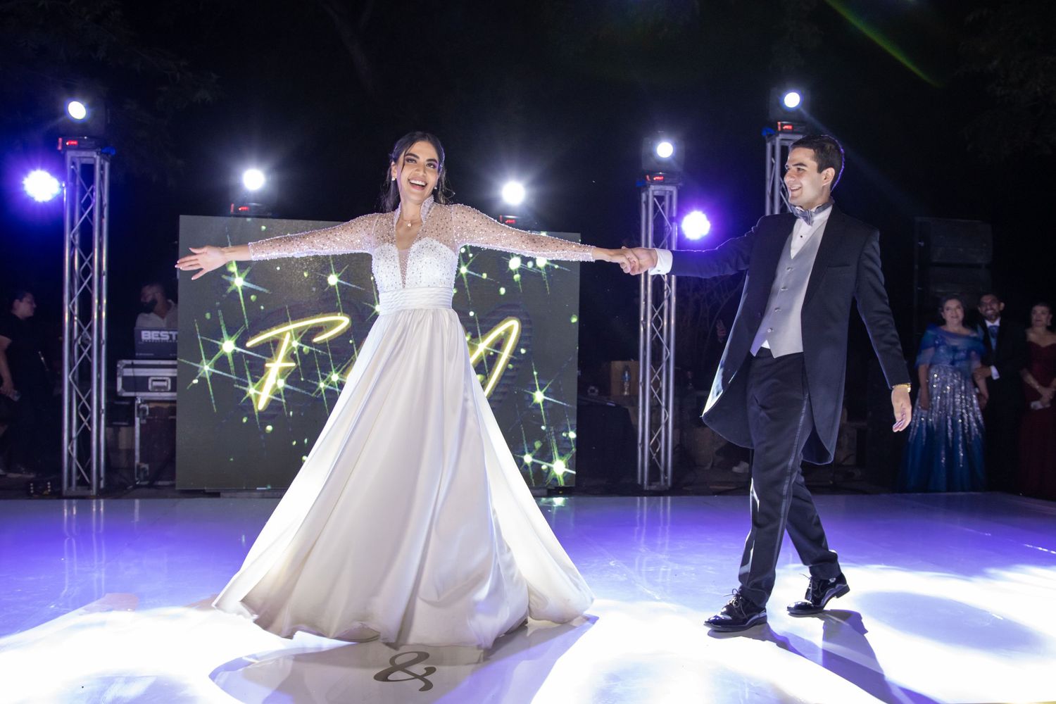 A bride in a flowing white gown twirls gracefully on a spotlit dance floor during a wedding celebration. Boda en Parras Coahuila, Fotógrafo