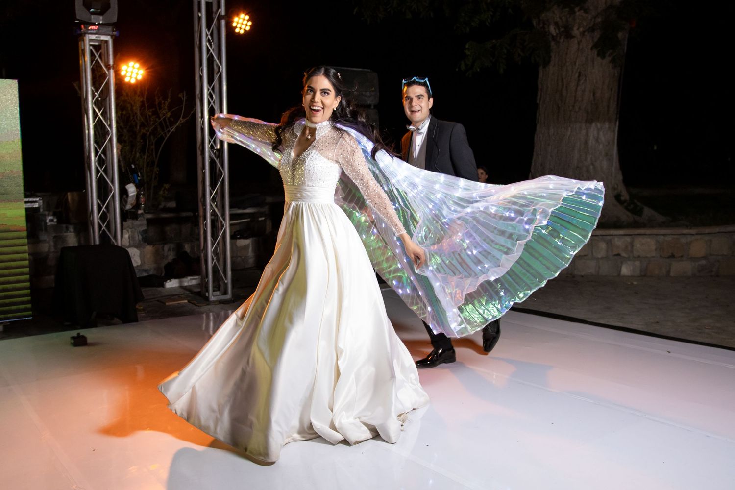 A flowing white wedding dress twirls on a lit dance floor during a nighttime celebration. Boda en Parras Coahuila, Fotógrafo de bodas