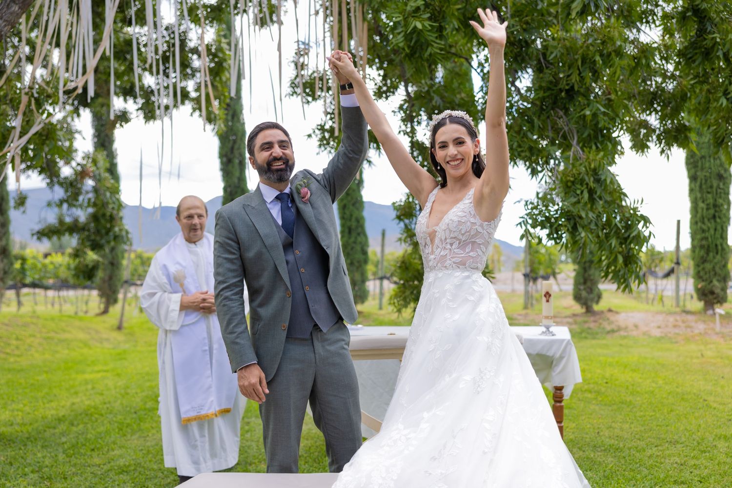 Celebratory moment at outdoor wedding with couple raising arms in joy. Boda en Parras Coahuila fotógrafo