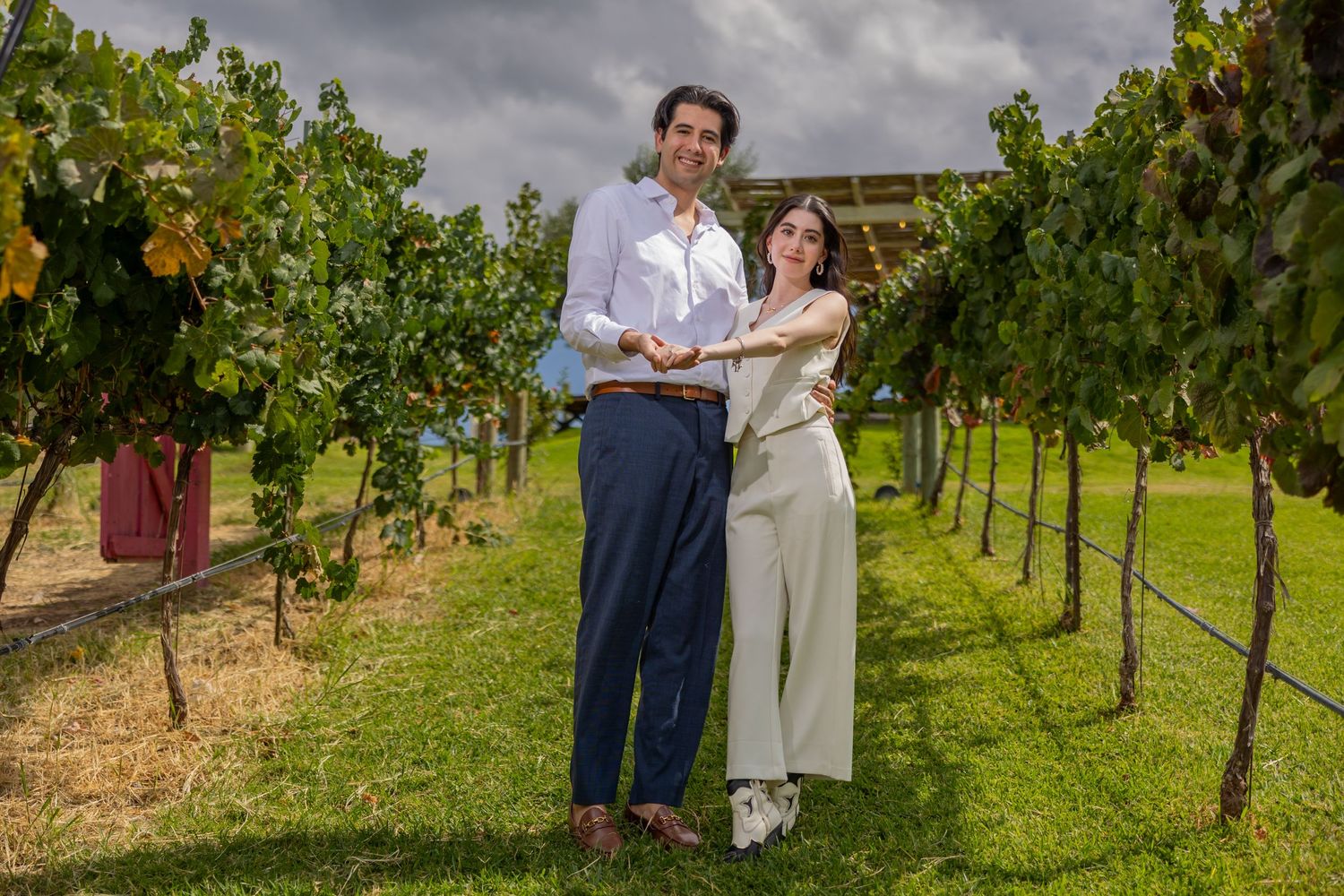A couple shares an intimate moment while standing between rows of grapevines in a vineyard. Propuesta de matrimonio Parras, Fotografo