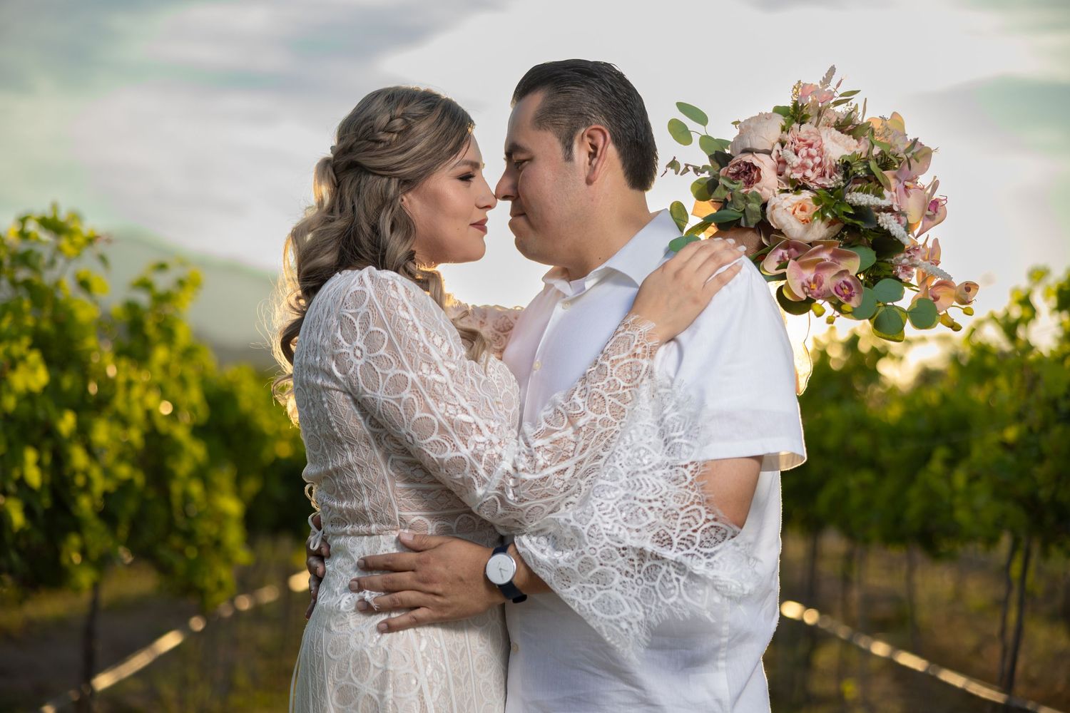 A romantic moment captured in a vineyard with pink floral bouquet. Sesión en Parras Coahuila