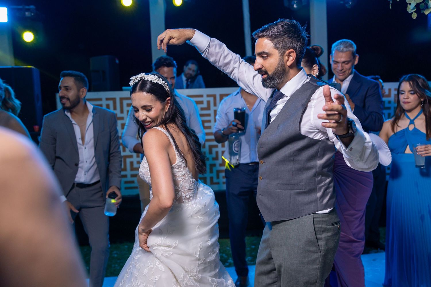 Couple performing choreographed dance move at wedding reception under blue lighting. Boda en Parras Coahuila fotógrafo