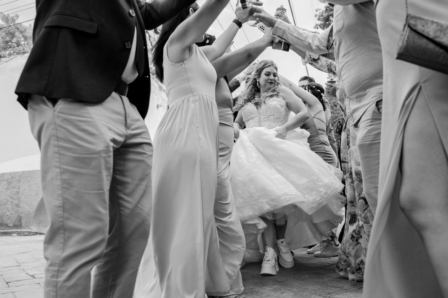 Black and white photo of guests dancing and celebrating at outdoor wedding party. Boda en Parras Coahuila fotógrafo