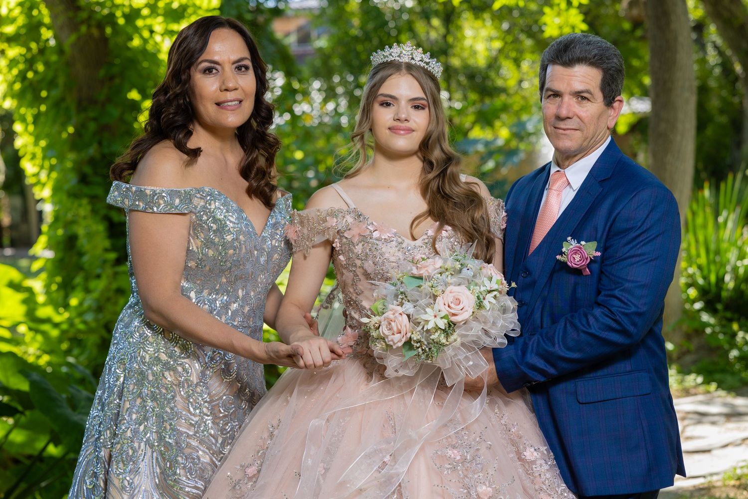 A celebration portrait featuring formal attire in blue and pink tones against a garden backdrop. Evento en Parras Coahuila , Fotógrafo Rulo