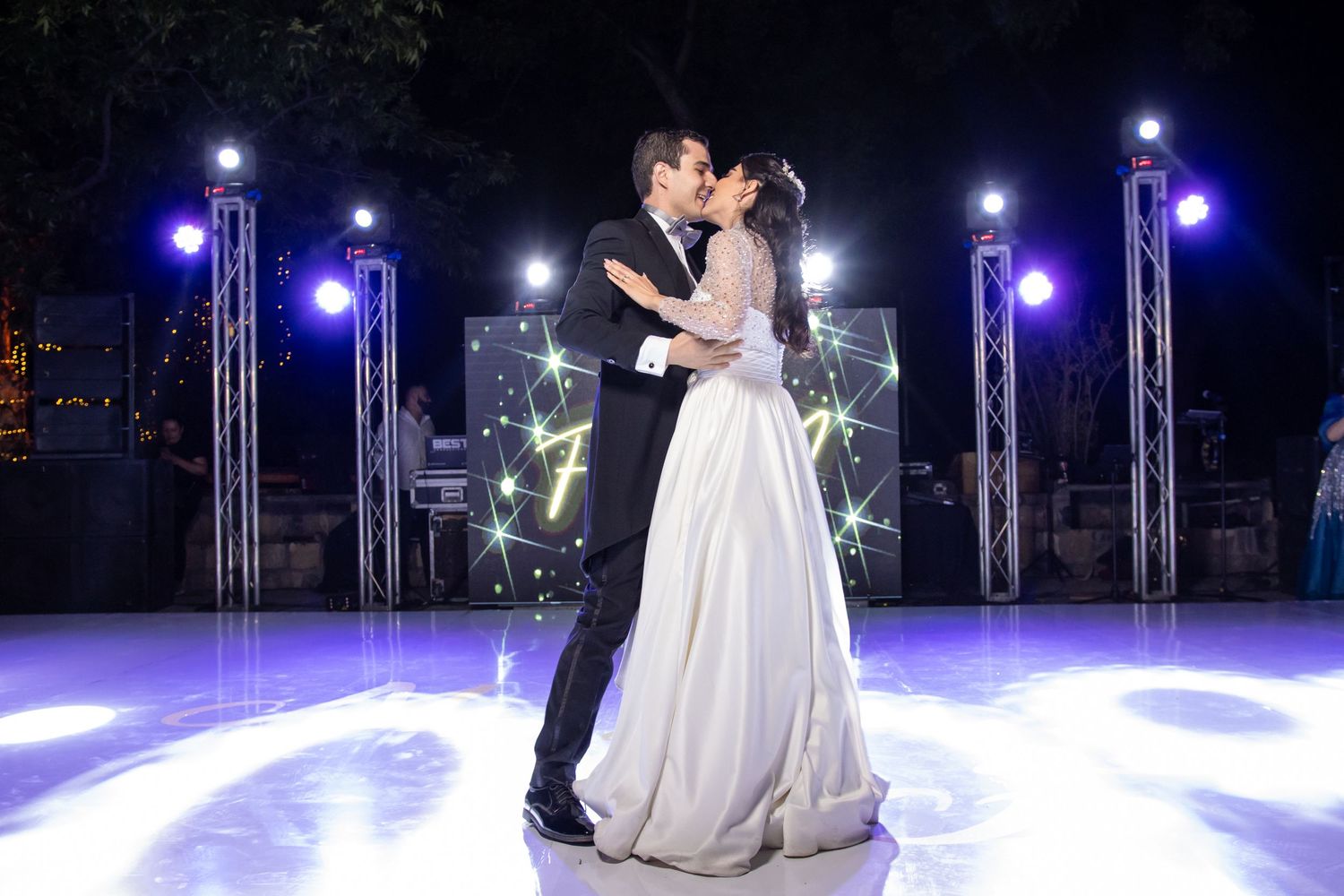 A romantic wedding dance moment captured on a brightly lit stage with theatrical lighting and decor. Boda en Parras Coahuila, Fotógrafo