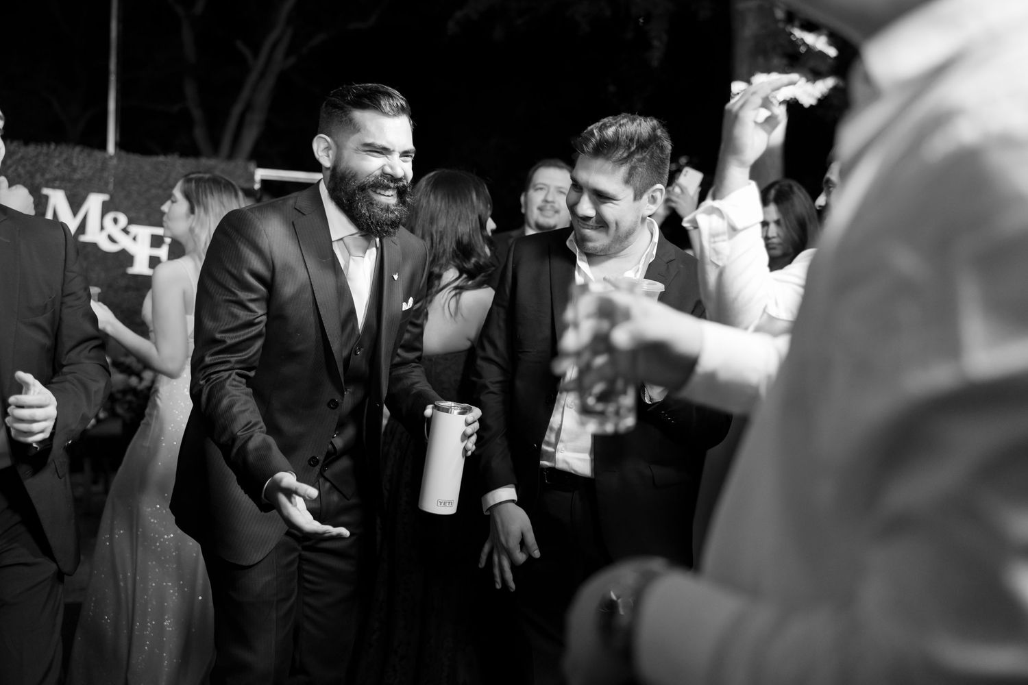 Guests enjoying a lively moment at an elegant evening reception in black and white photography. Boda en Parras Coahuila, Fotógrafo de bodas,