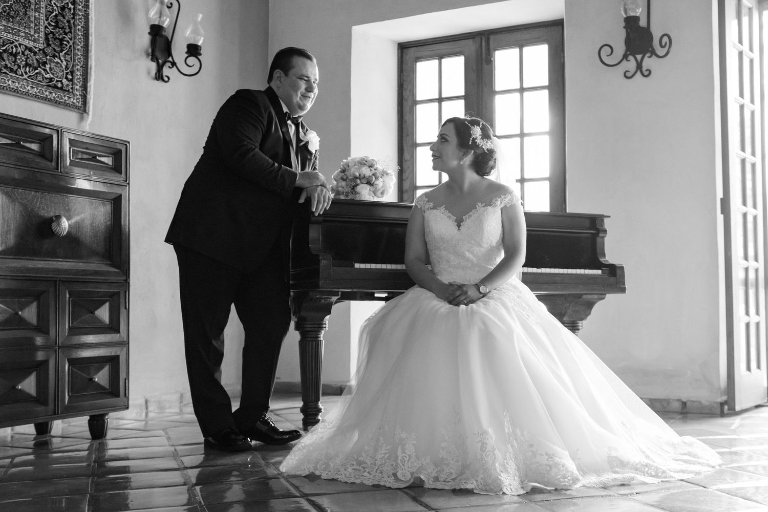 Black and white photo showing elegant scene with grand piano in classic interior. boda en Parras Coahuila fotógrafo