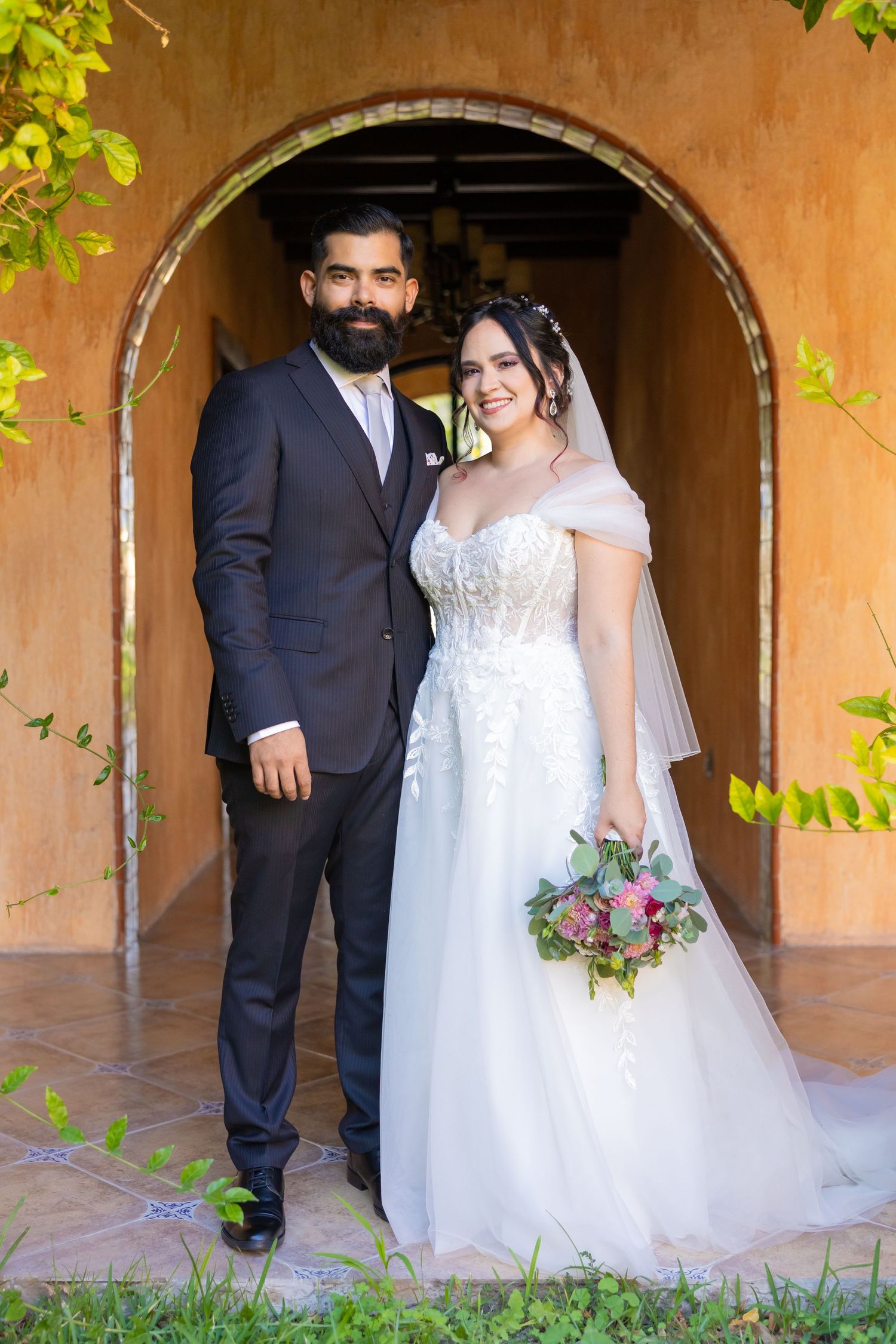 A wedding portrait under a rustic archway with beautiful garden scenery. Boda en Parras Coahuila, Fotógrafo de bodas