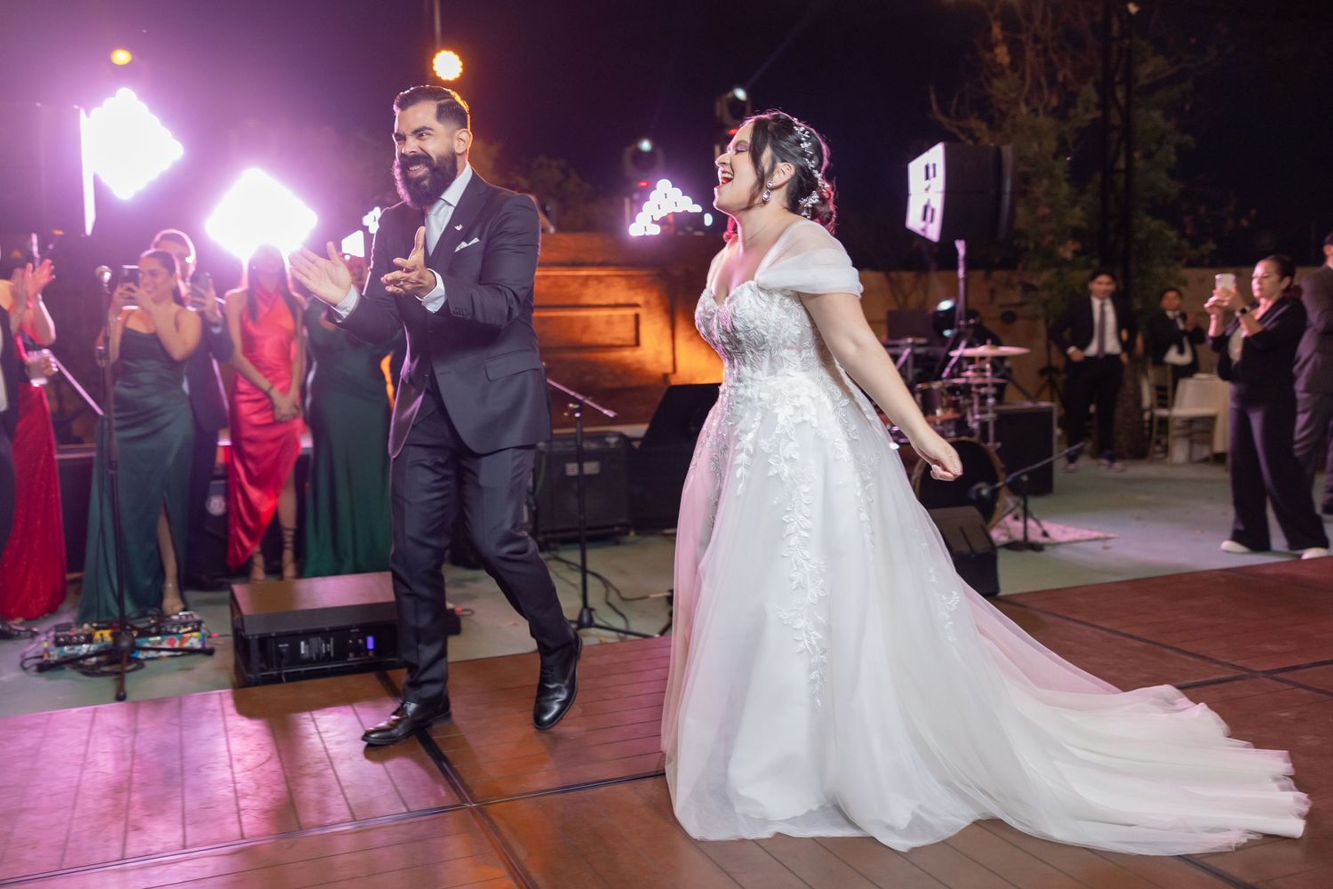Couple performs lively dance routine at wedding reception with purple lighting and guests watching. Boda en Parras Coahuila, Fotógrafo
